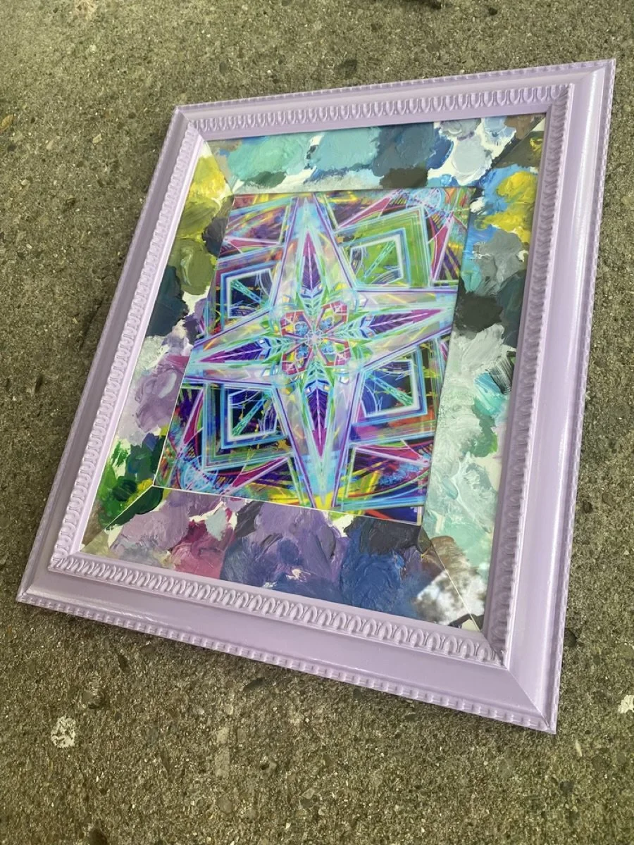 A framed artwork with a colorful abstract geometric design featuring neon-like lines, placed on a textured ground surface.