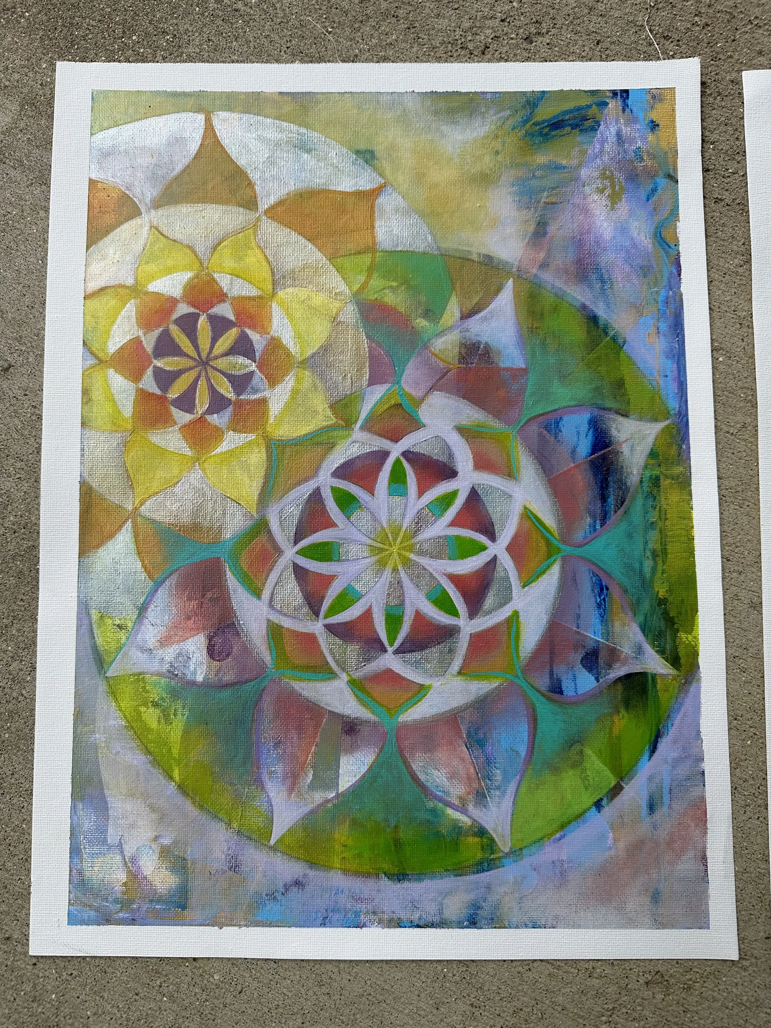 Colorful watercolor painting featuring concentric floral patterns with geometric shapes and a vibrant mix of greens, blues, purples, and warm tones.