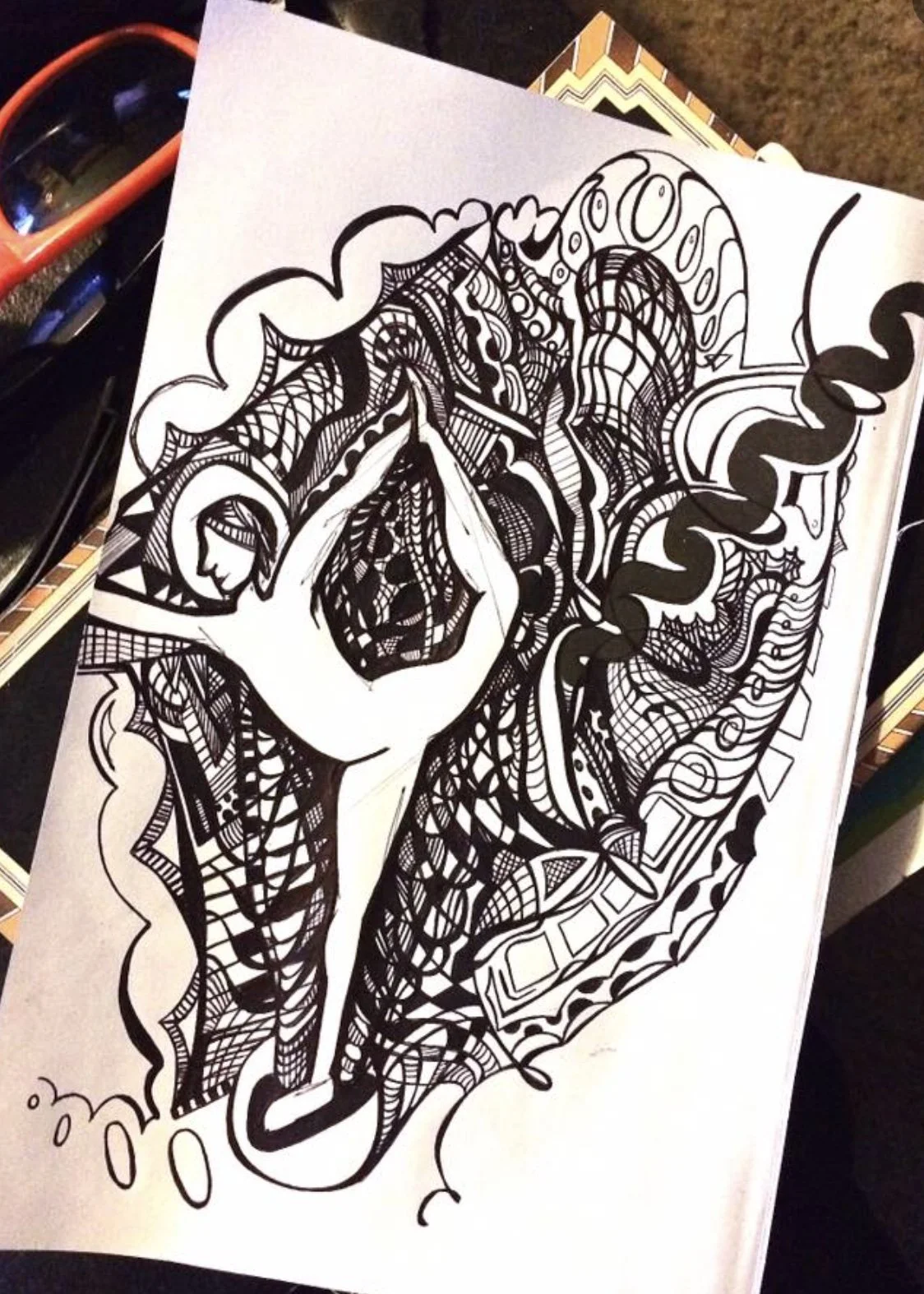 A black and white abstract drawing of a woman with a handcombing her hair, surrounded by intricate patterns and lines.