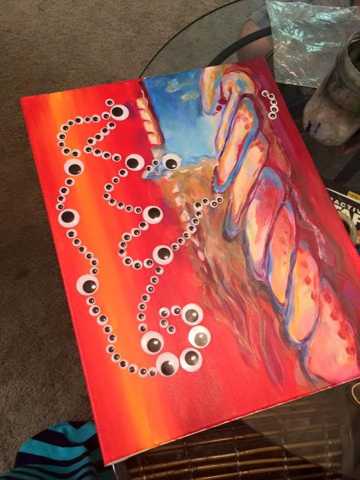 A colorful abstract painting with a red background, featuring swirling patterns in blue, orange, yellow, and pink. There are large googly eyes and smaller black and white eyes arranged in a pattern across the artwork.