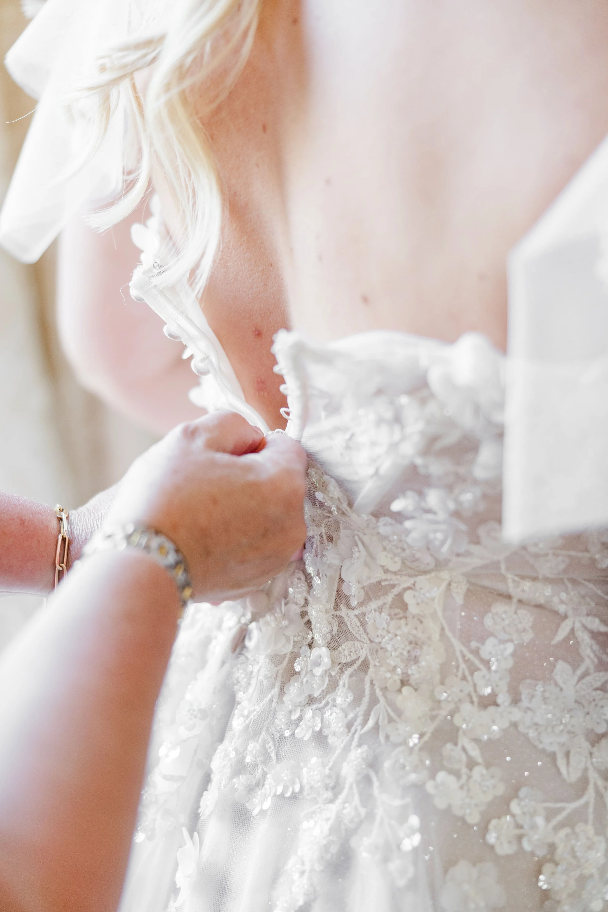 bride getting in the dress with her mom