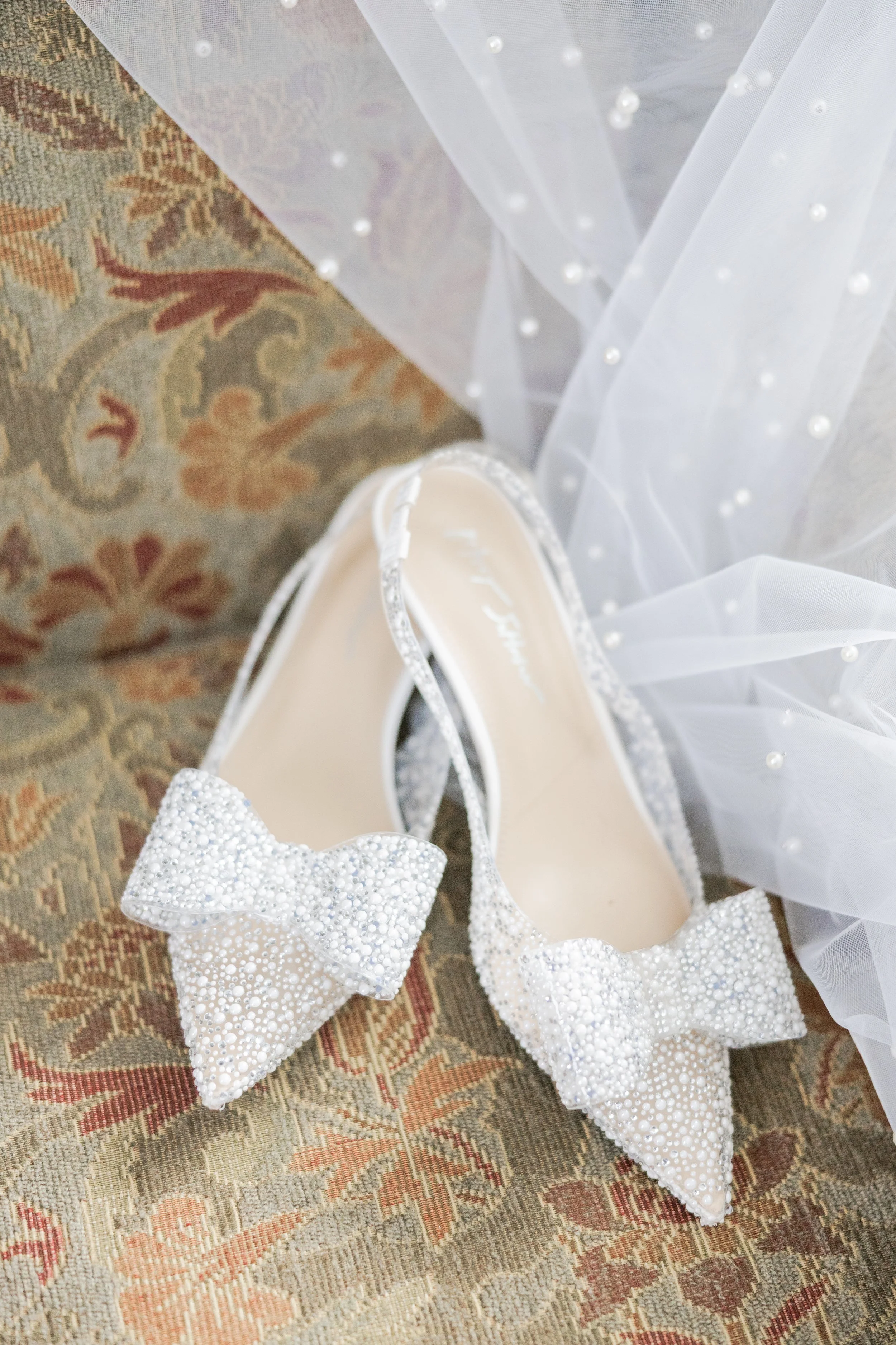 Close-up of elegant white bridal shoes with lace details