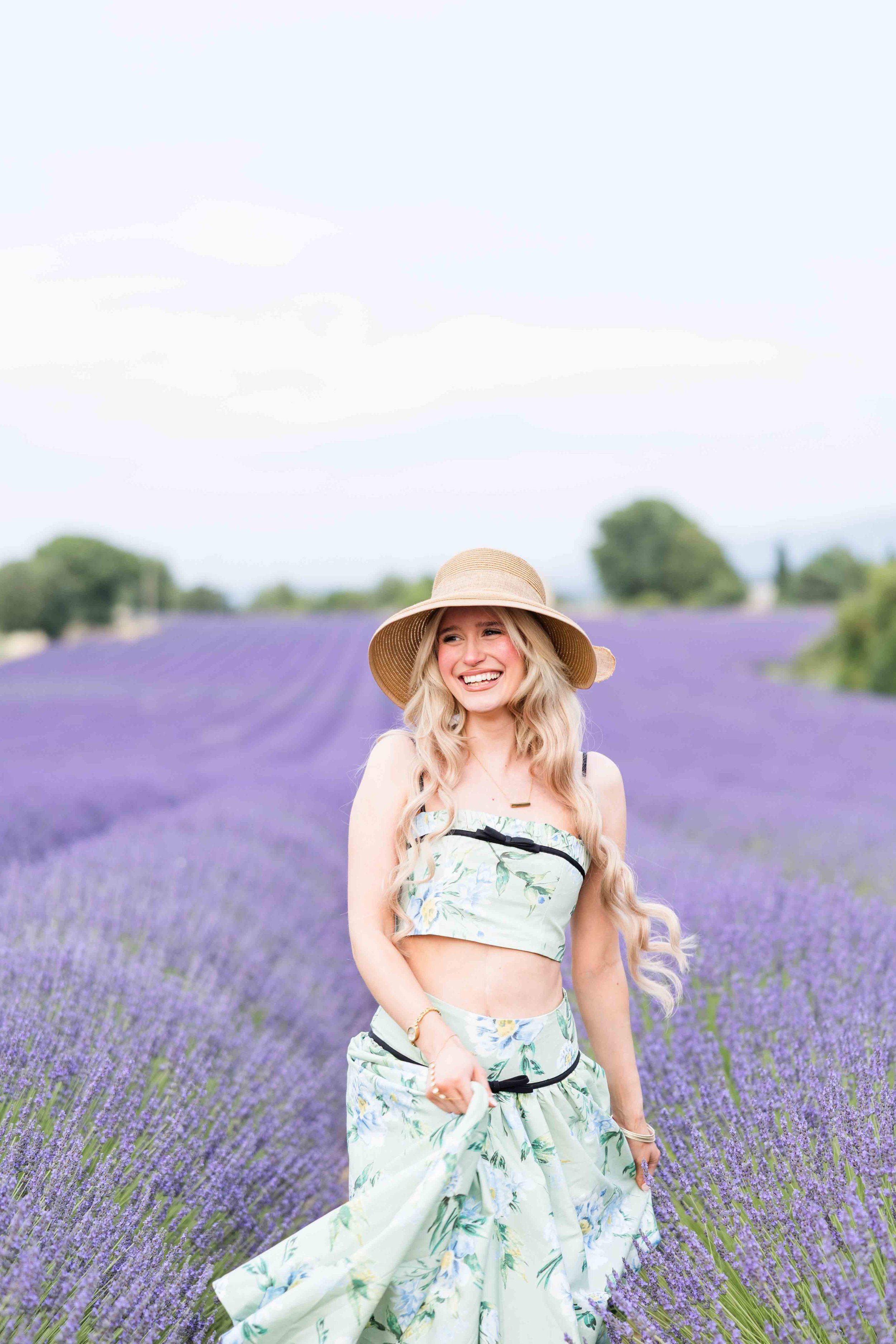  Woman posing in a flowing dress surrounded by lavender blooms in Provence. 