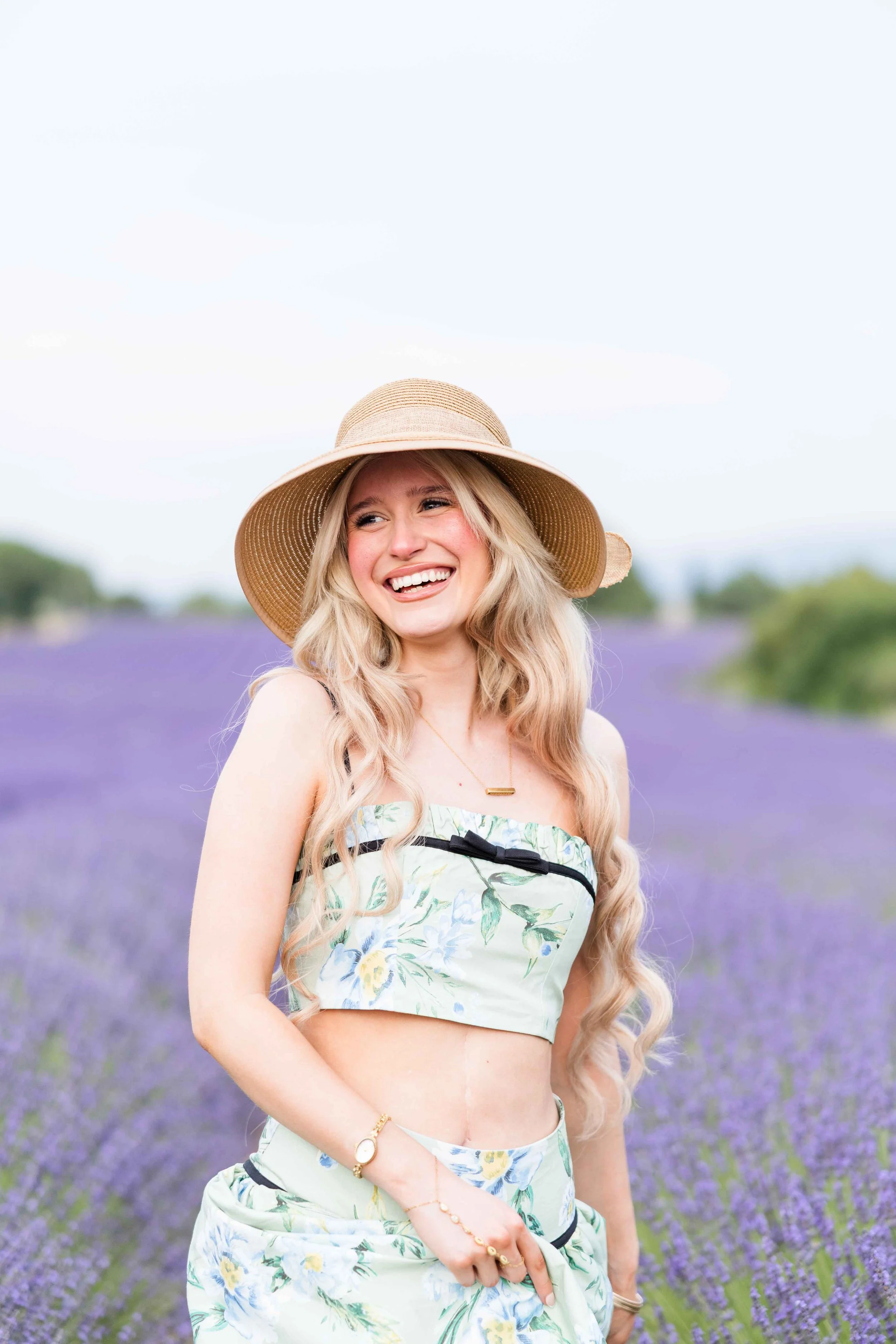  Soft portrait of a smiling woman in Provence lavender fields at golden hour. 