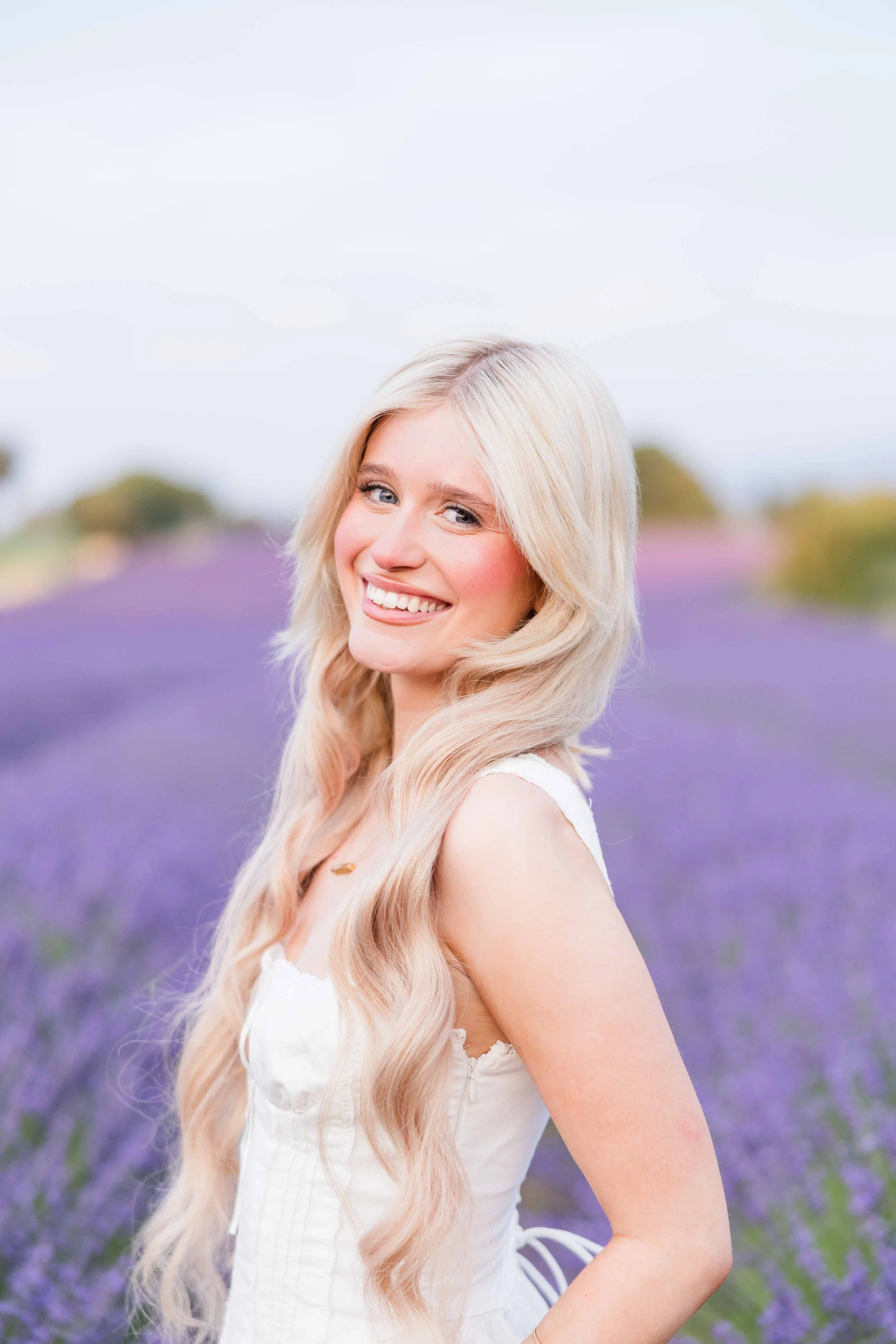  Close-up portrait of a smiling blonde woman in lavender fields in Provence. 