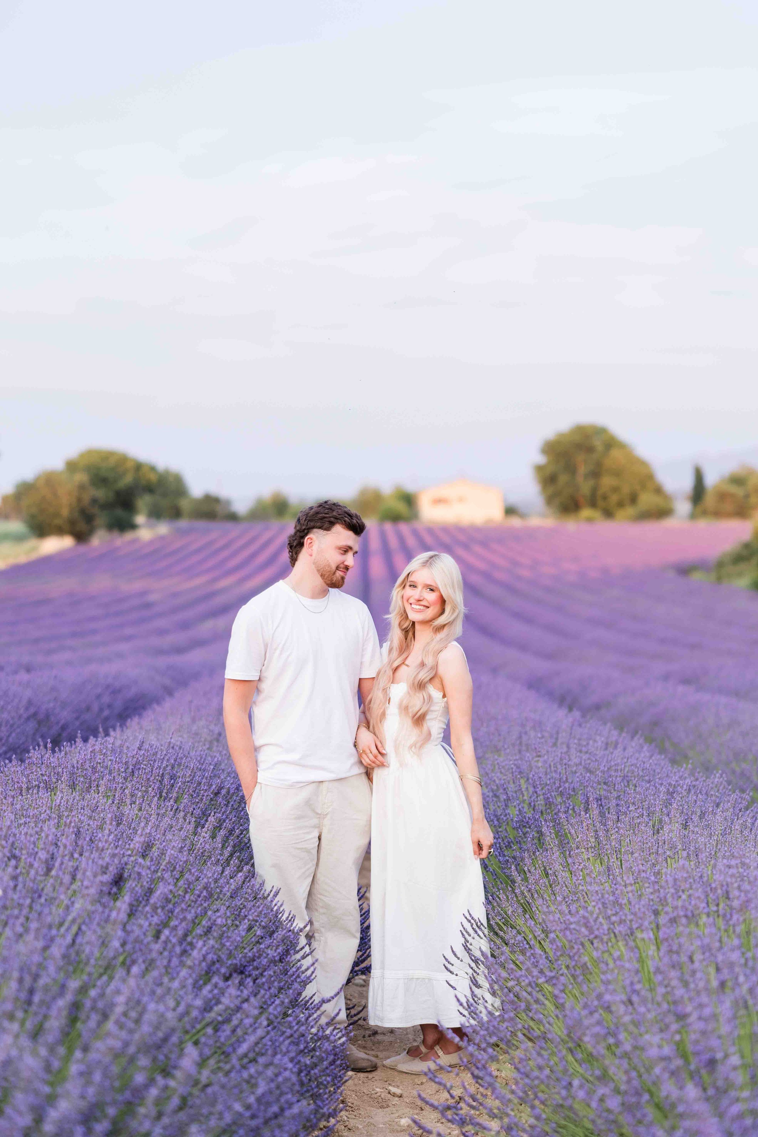  Couple walking through blooming lavender fields during a Provence photoshoot. 
