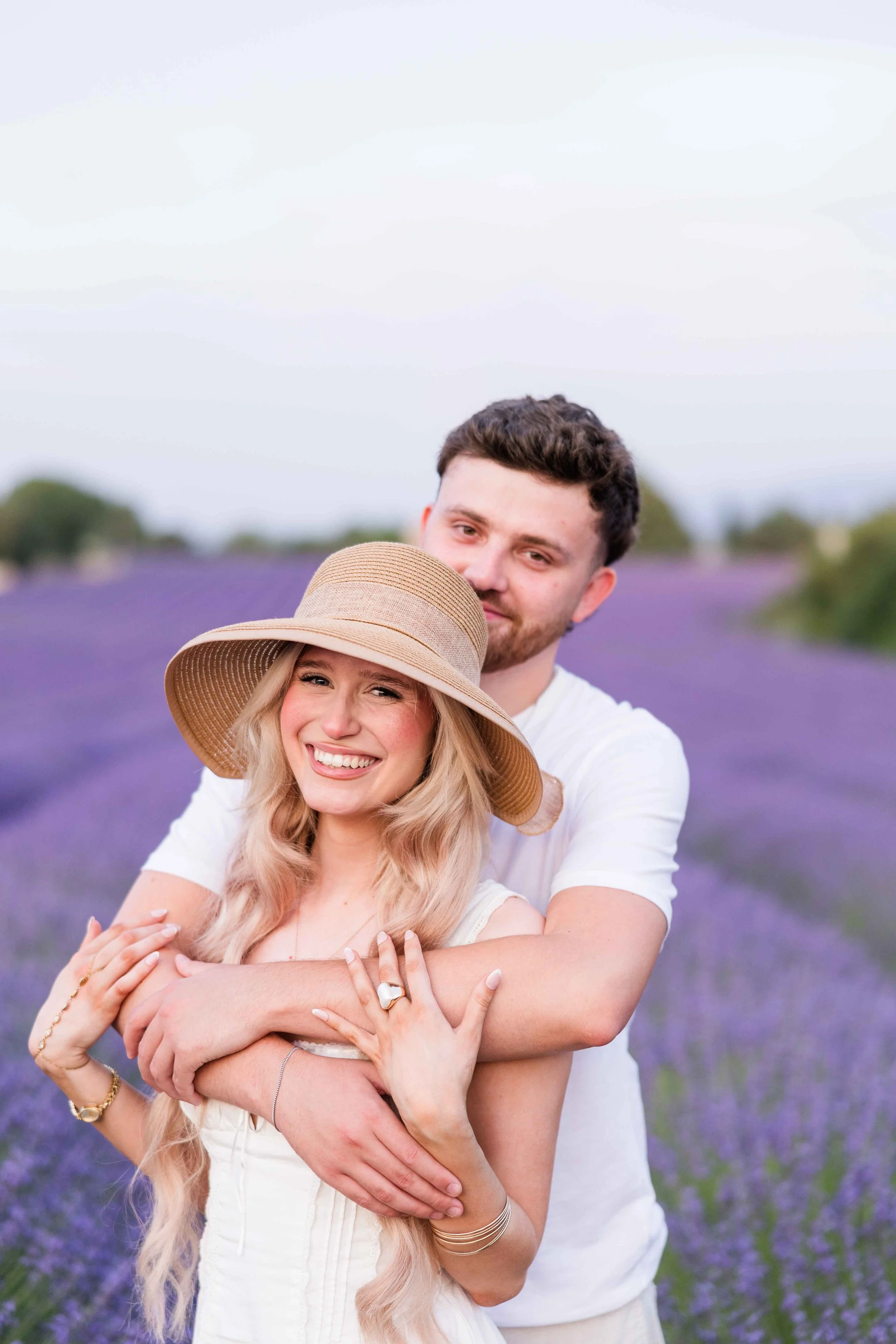  Couple standing together in a lavender field during a sunset photoshoot in Provence. 