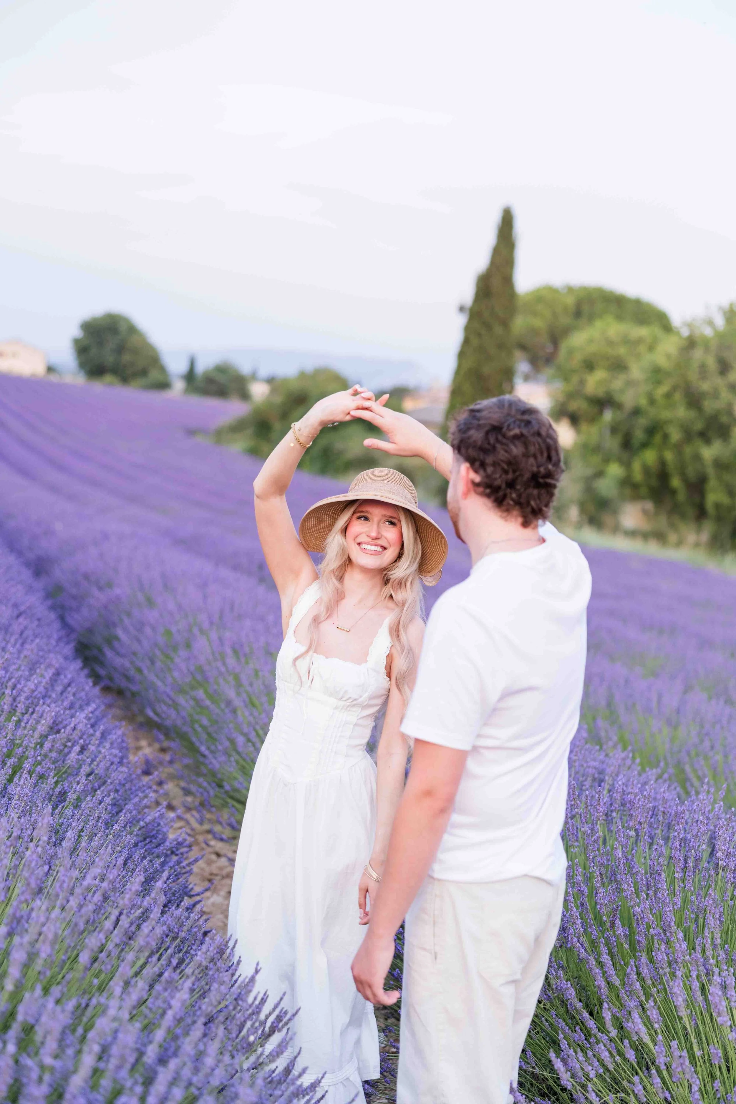  Couple standing together in a lavender field during a sunset photoshoot in Provence. 