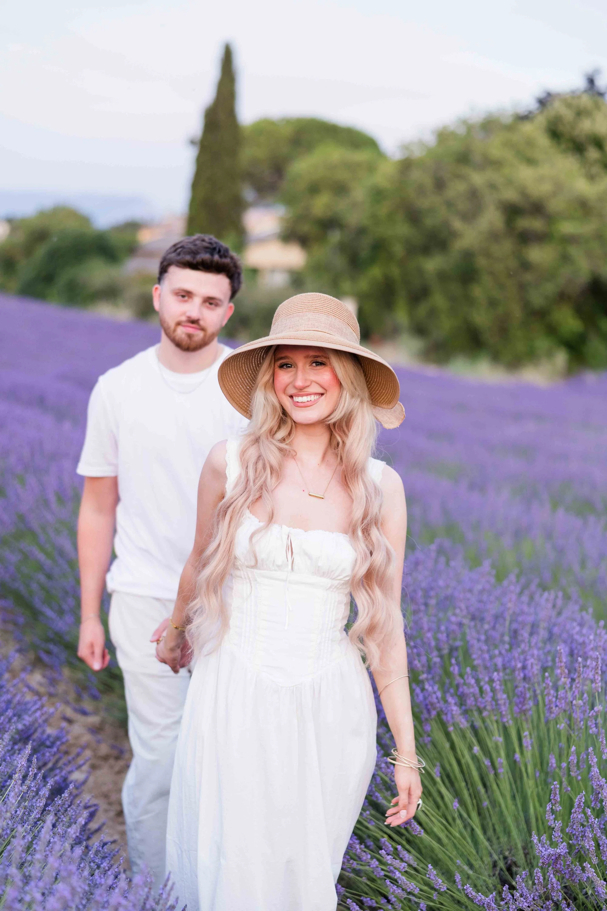  Couple walking through blooming lavender fields during a Provence photoshoot. 