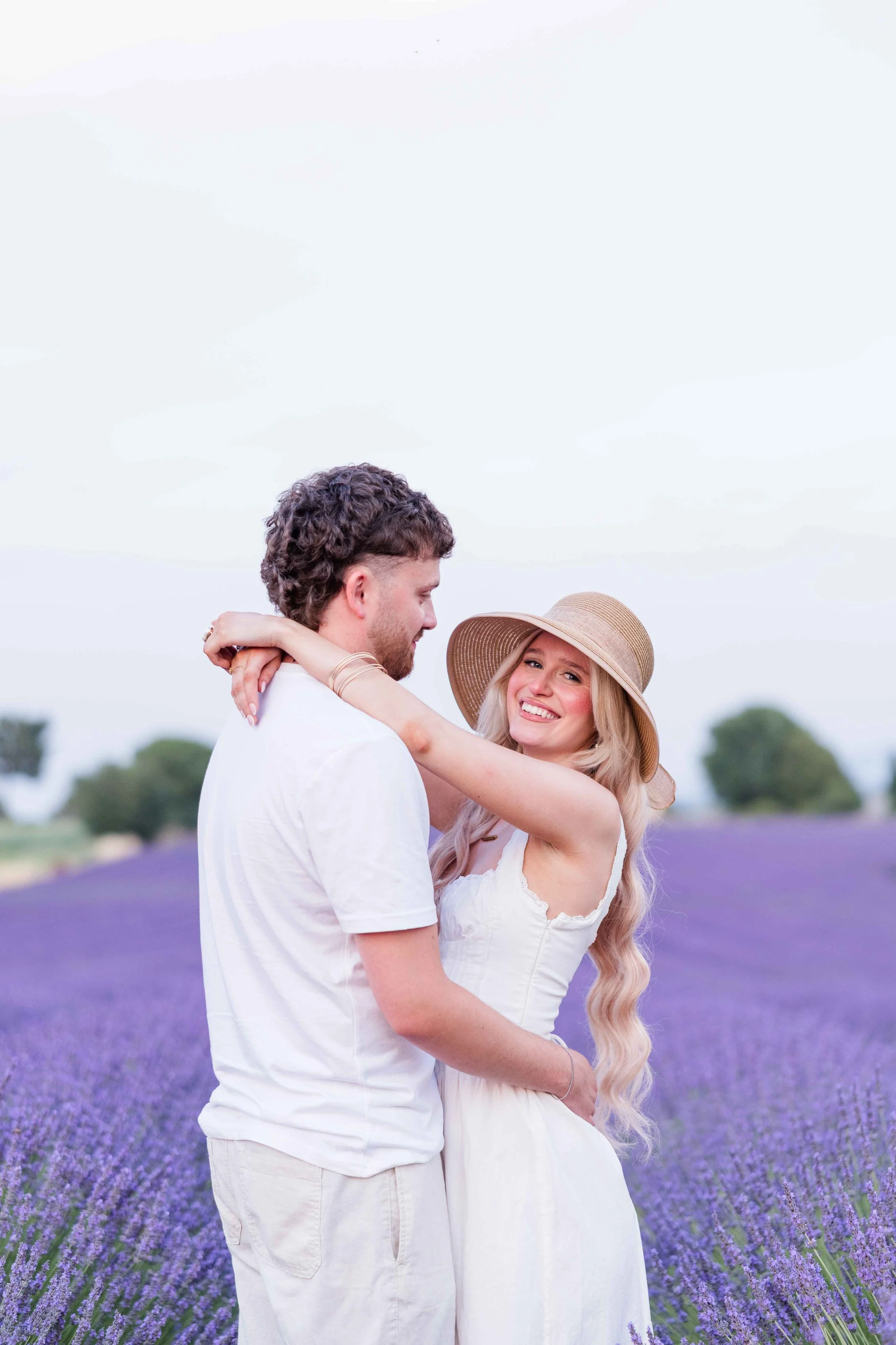  Couple standing together in a lavender field during a sunset photoshoot in Provence. 