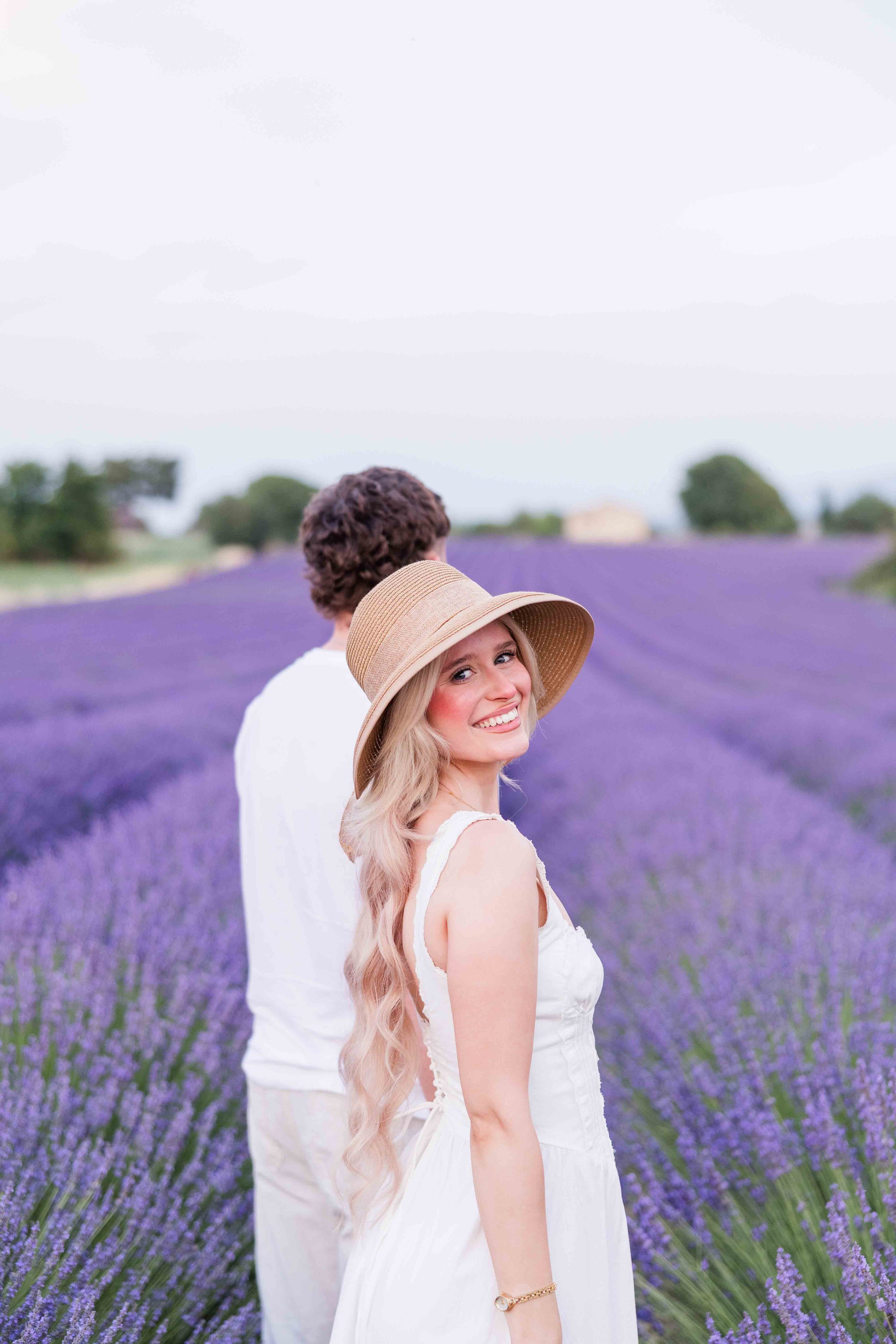  Couple standing together in a lavender field during a sunset photoshoot in Provence. 