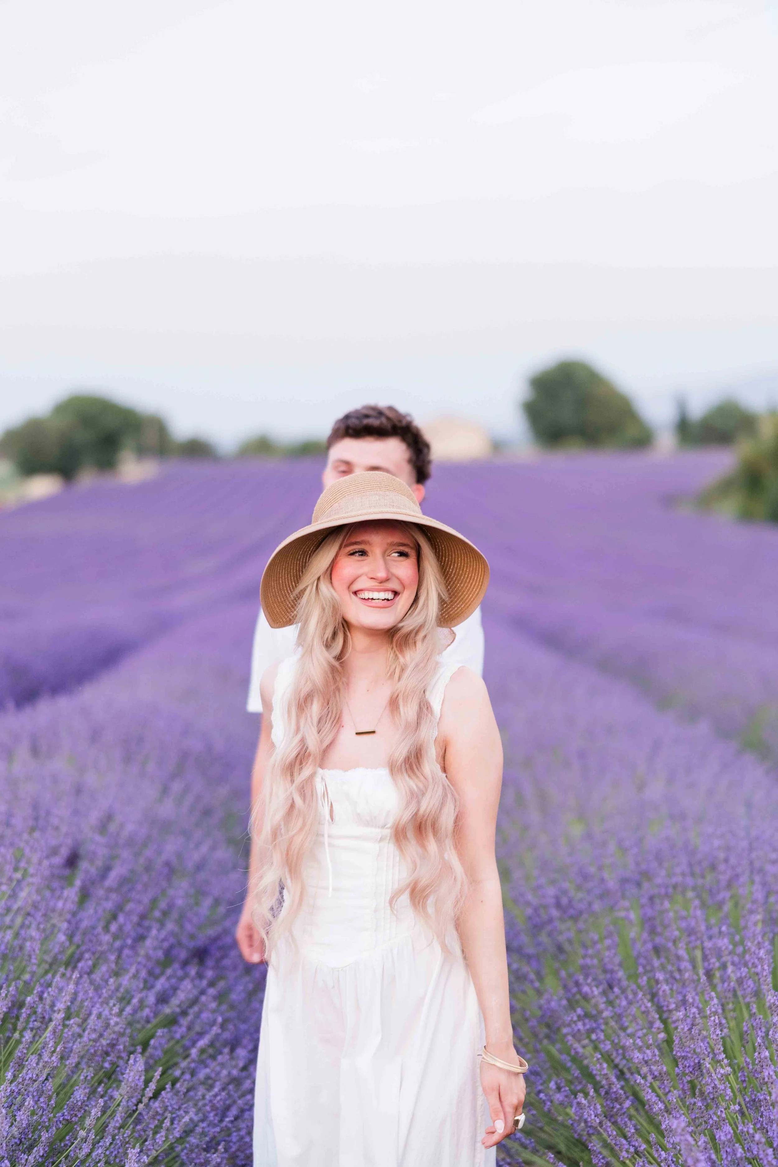  Couple walking through blooming lavender fields during a Provence photoshoot. 
