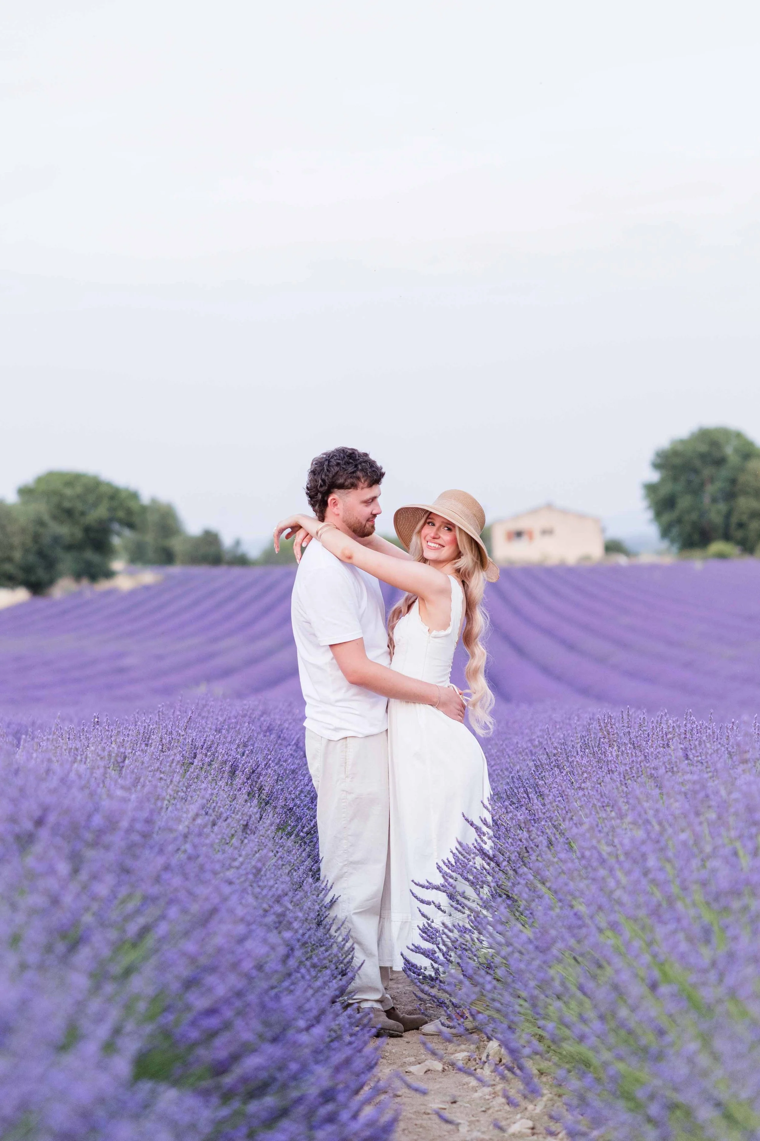 Couple standing together in a lavender field during a sunset photoshoot in Provence.