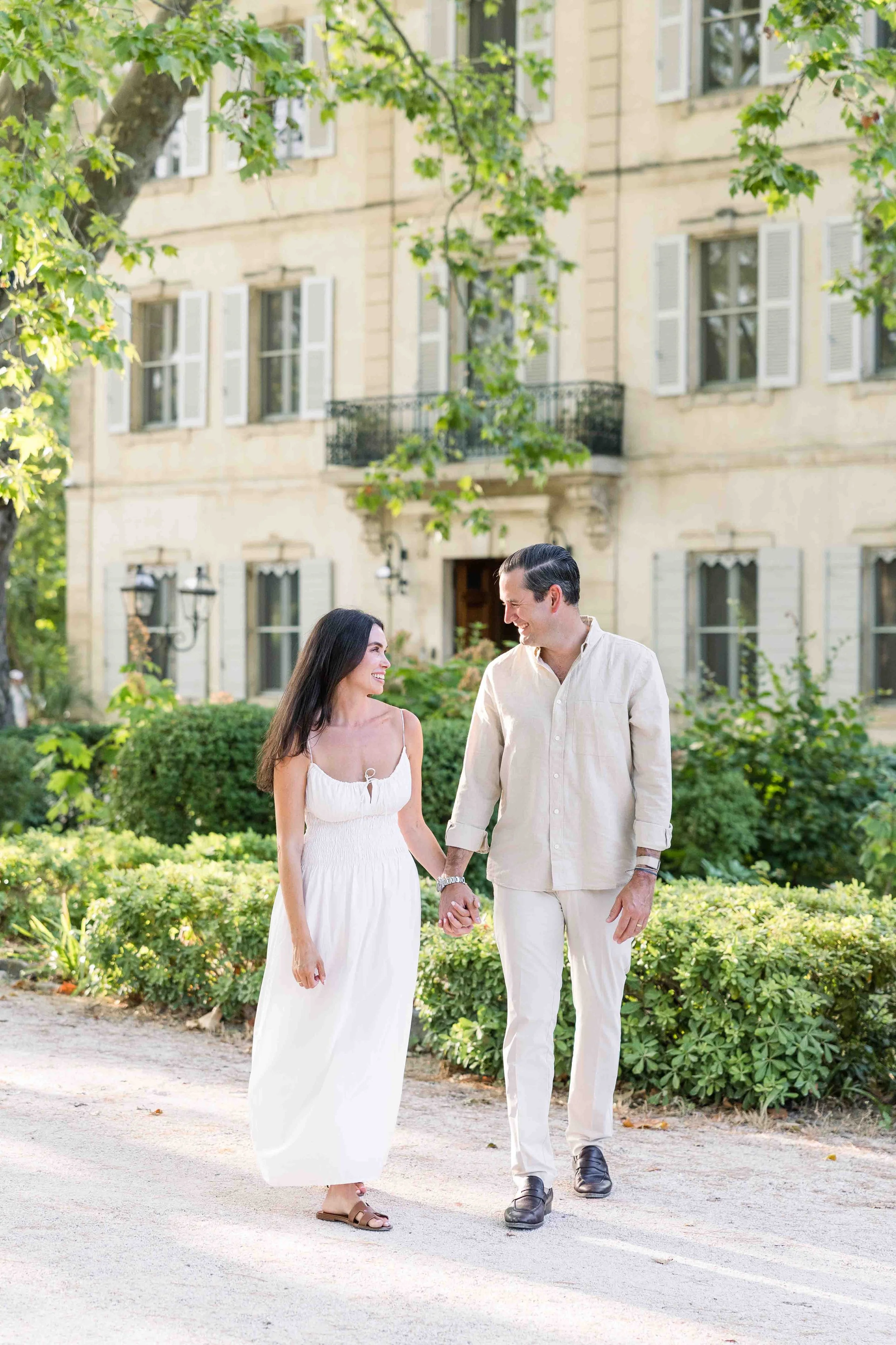 Couple walking through Château des Alpilles gardens