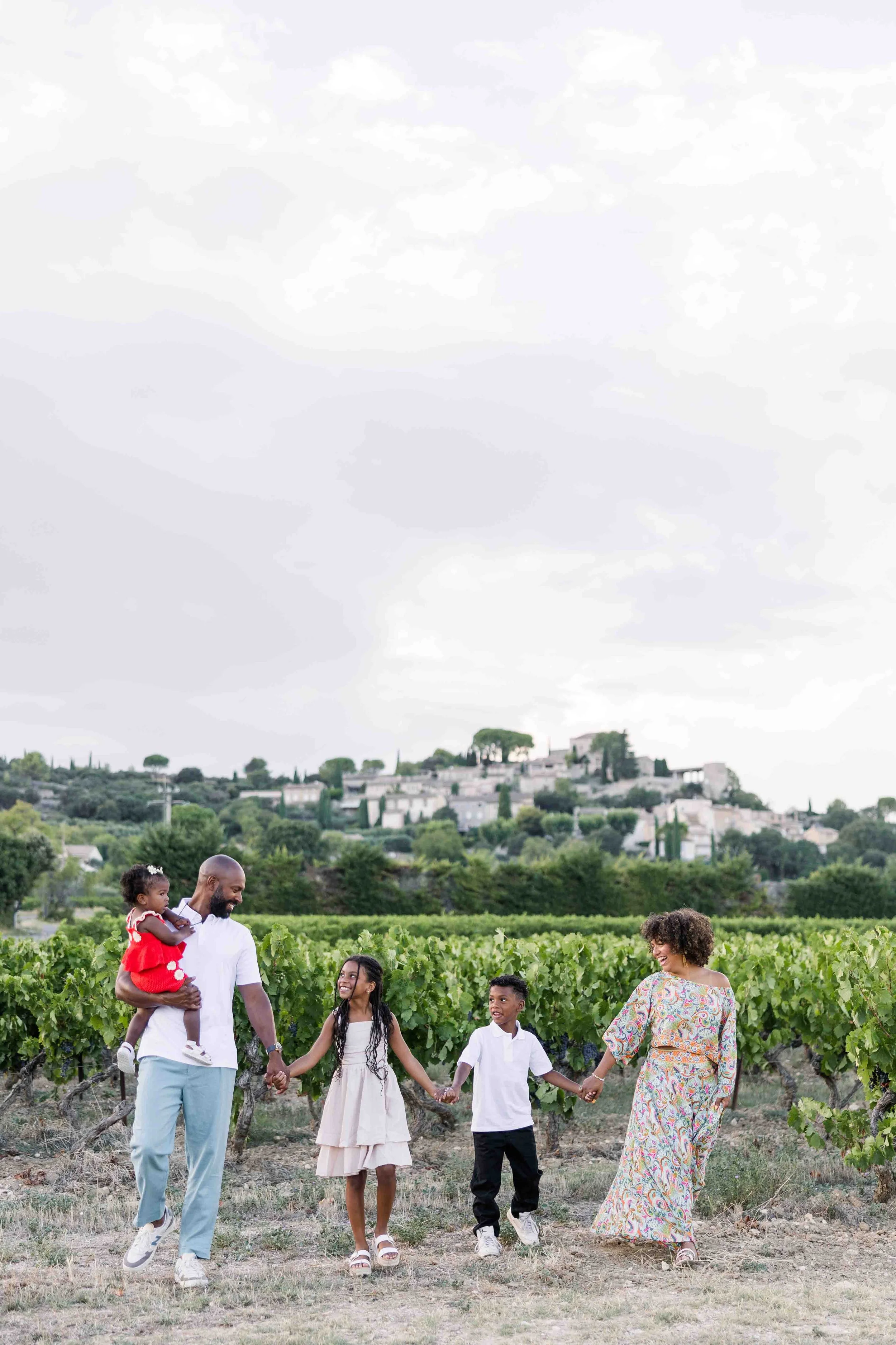 family walking in a vineyard near joucas and gordes during a family session in Provence during their stay