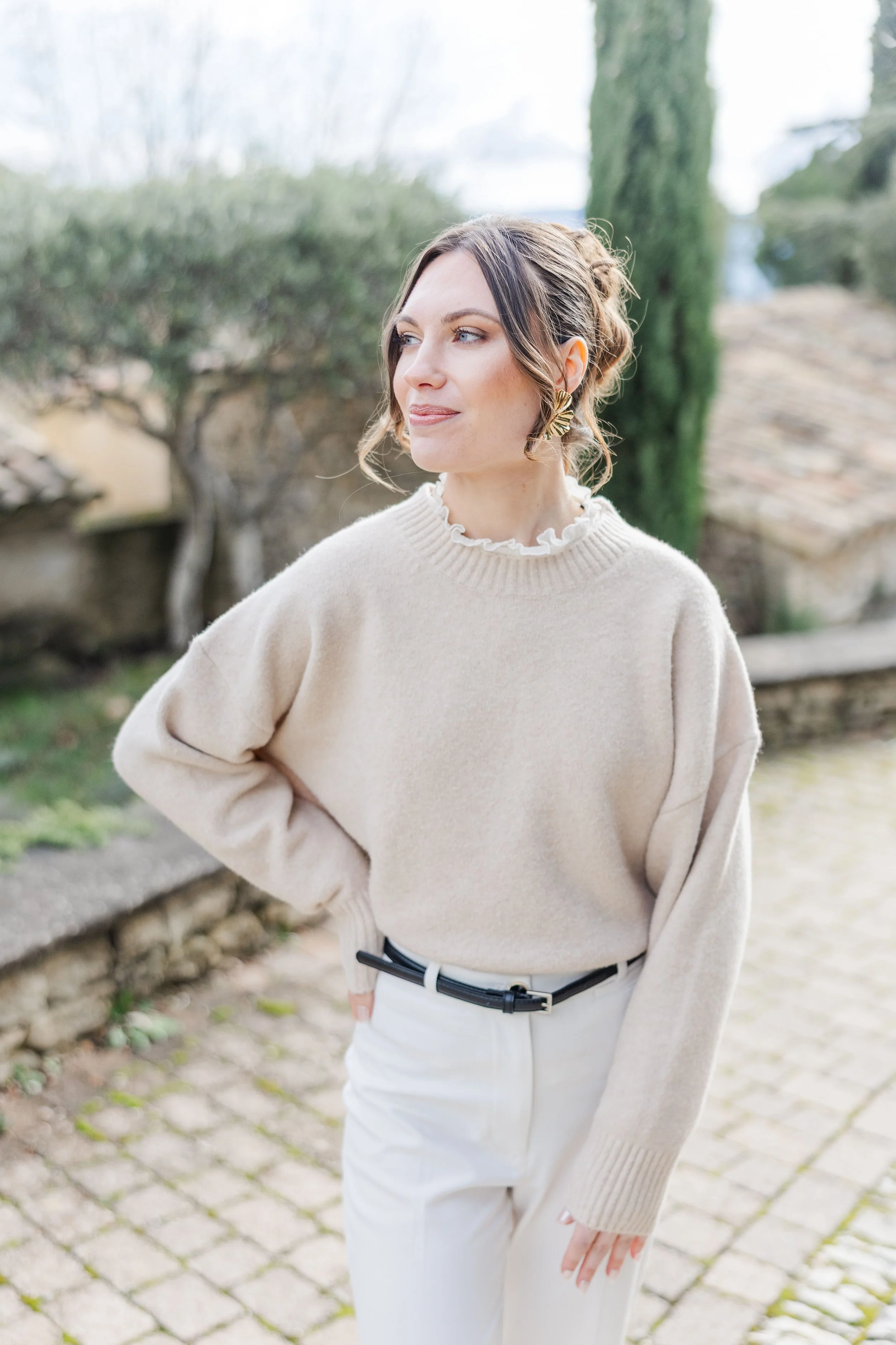 Woman enjoying golden hour light among pink flowers in Gordes, Provence