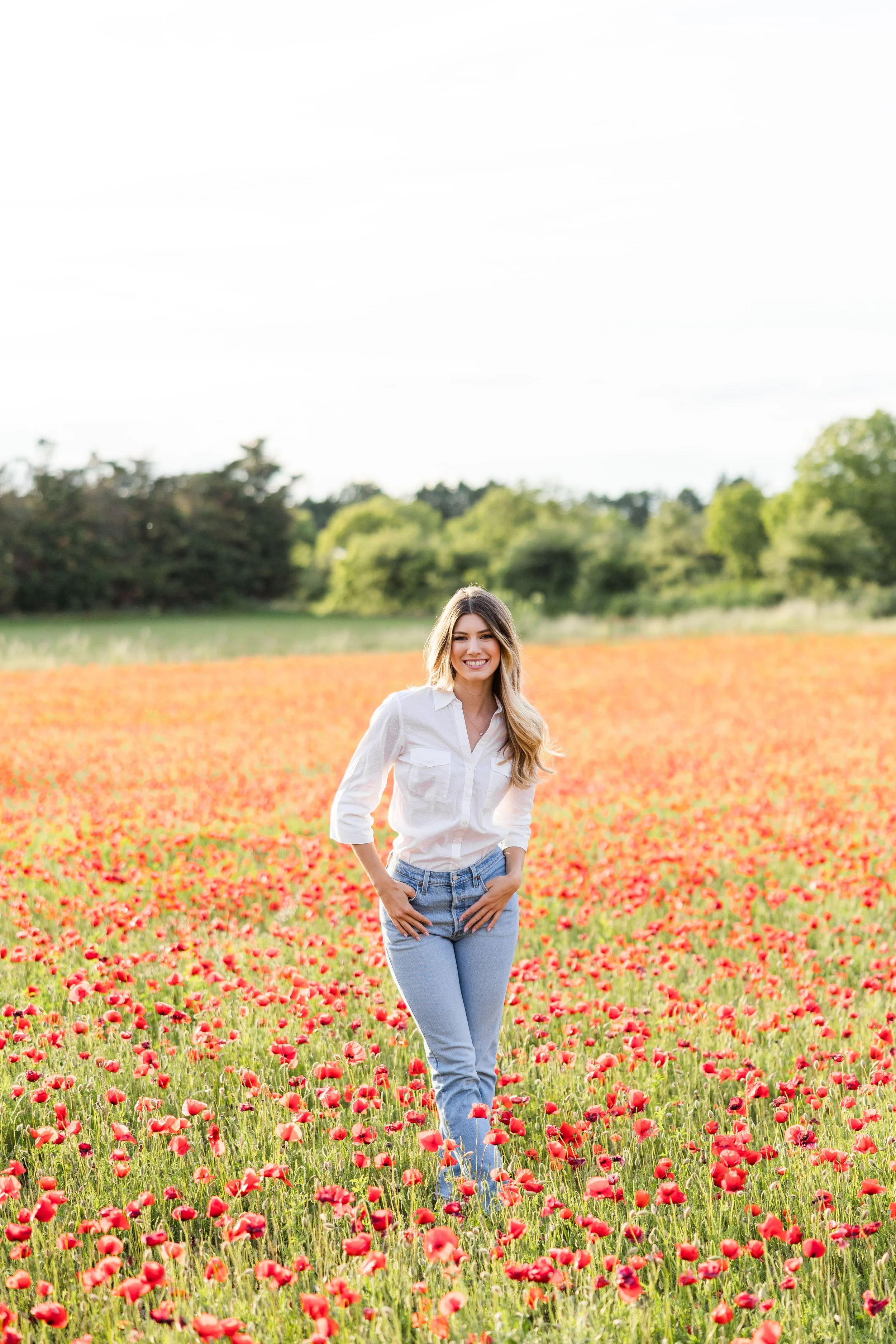 Portrait of a woman in a poppy field during golden hour in Provence