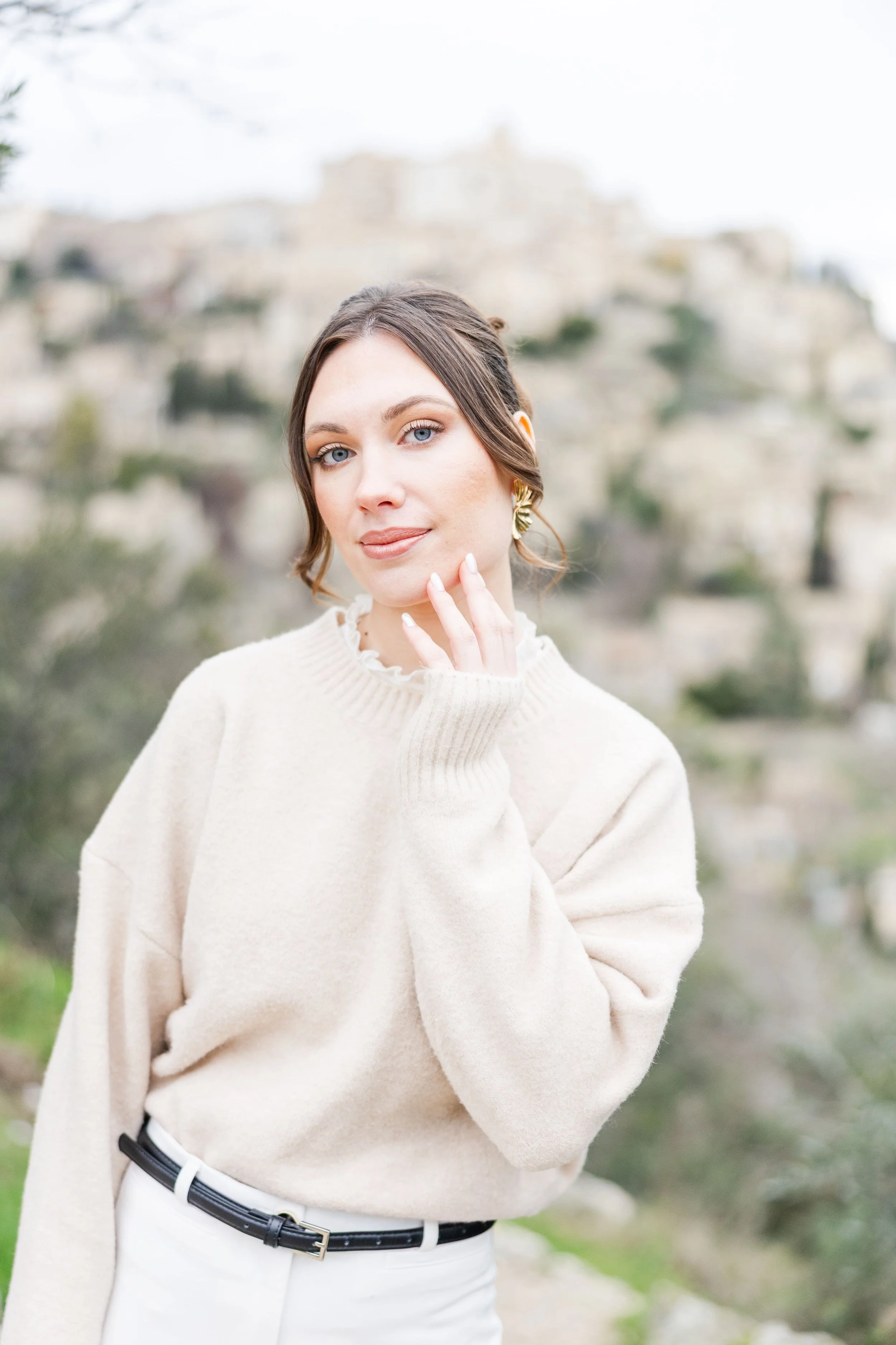 Solo female lifestyle portrait in Gordes walking through sunlit stone streets in the South of France