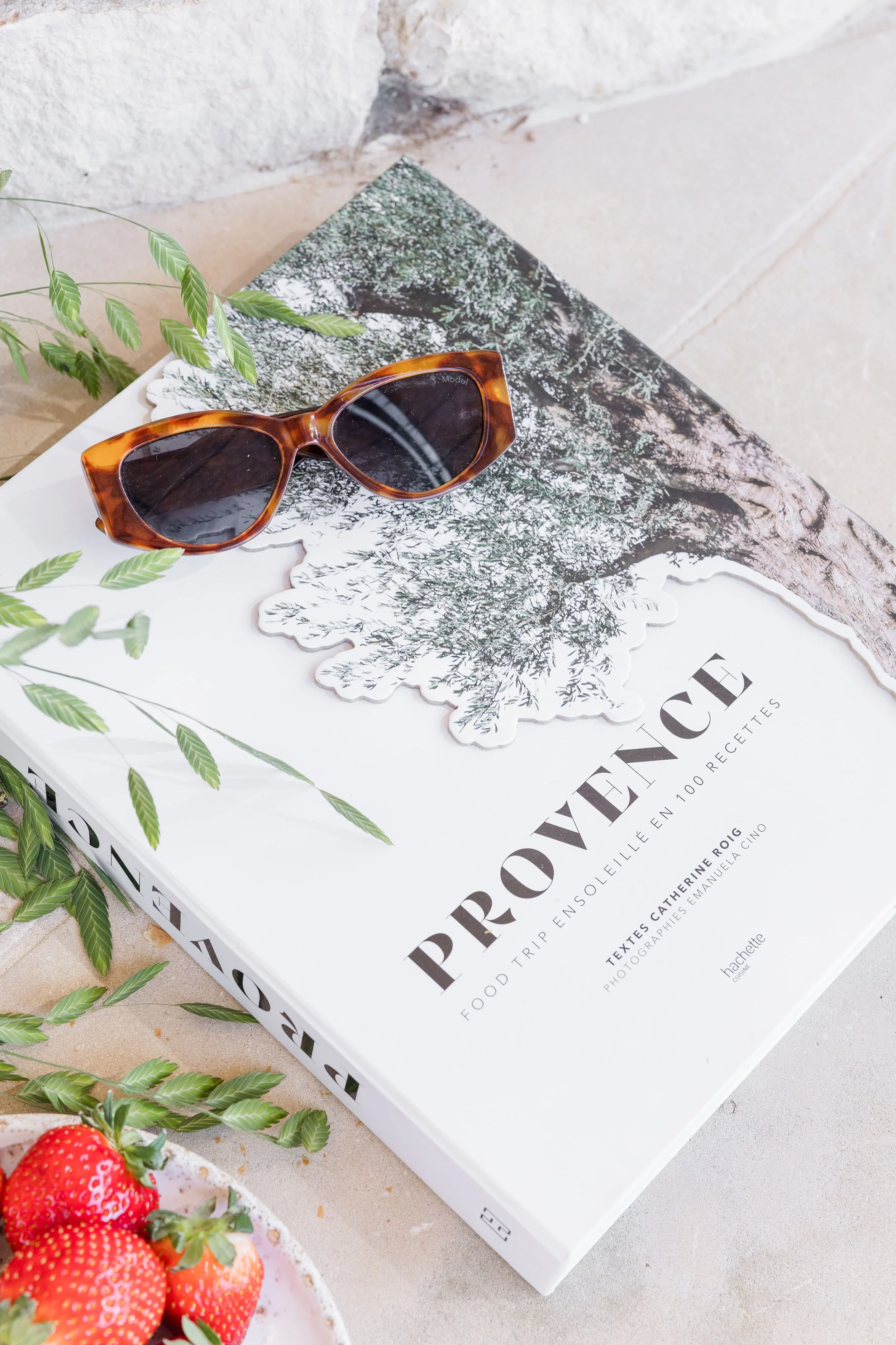 Woman reading a Provence-inspired book with sunglasses by the pool in a luxury villa in Gordes