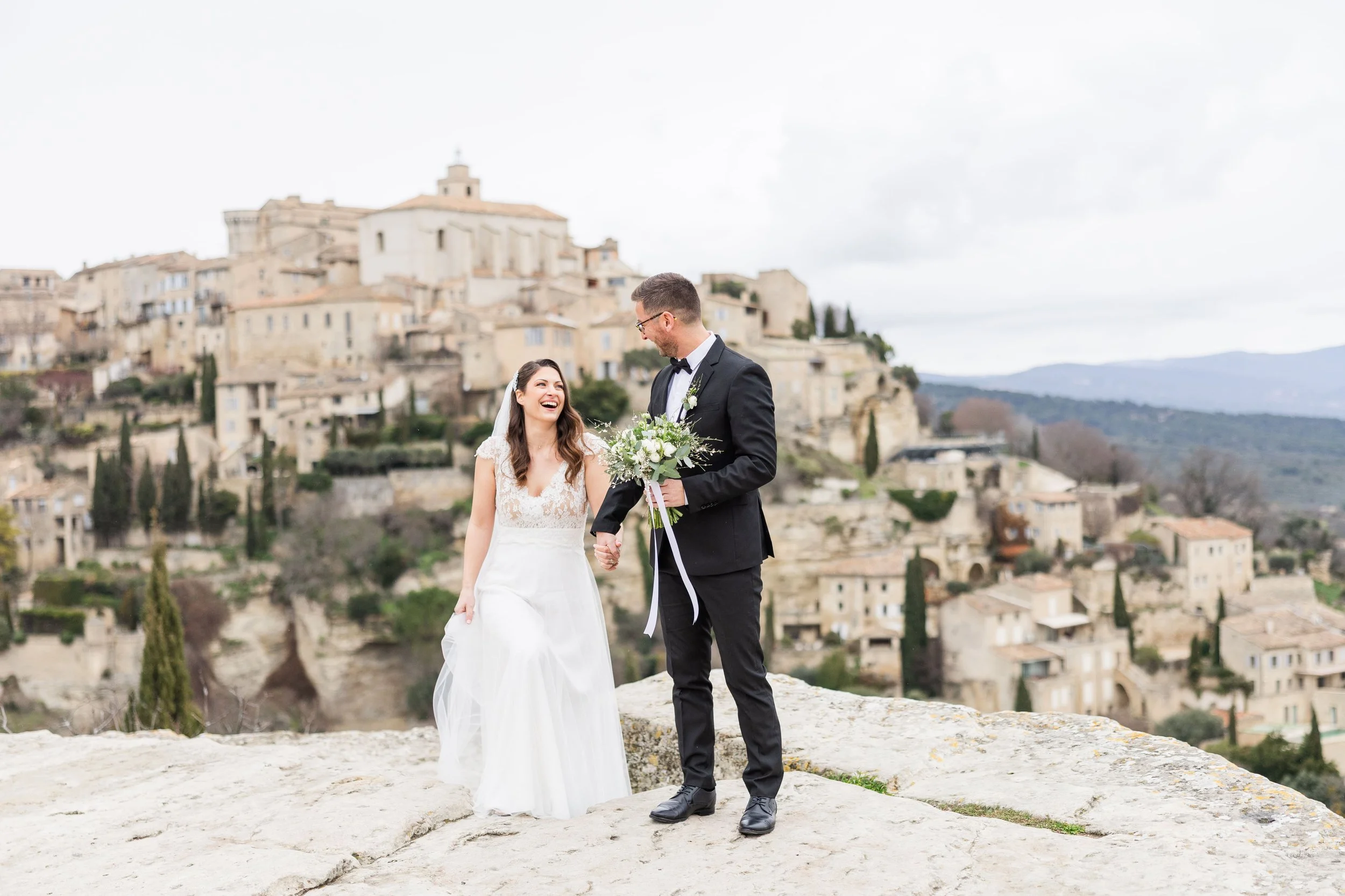 bride and groom in Gordes, after their first look, holding hands and smiling