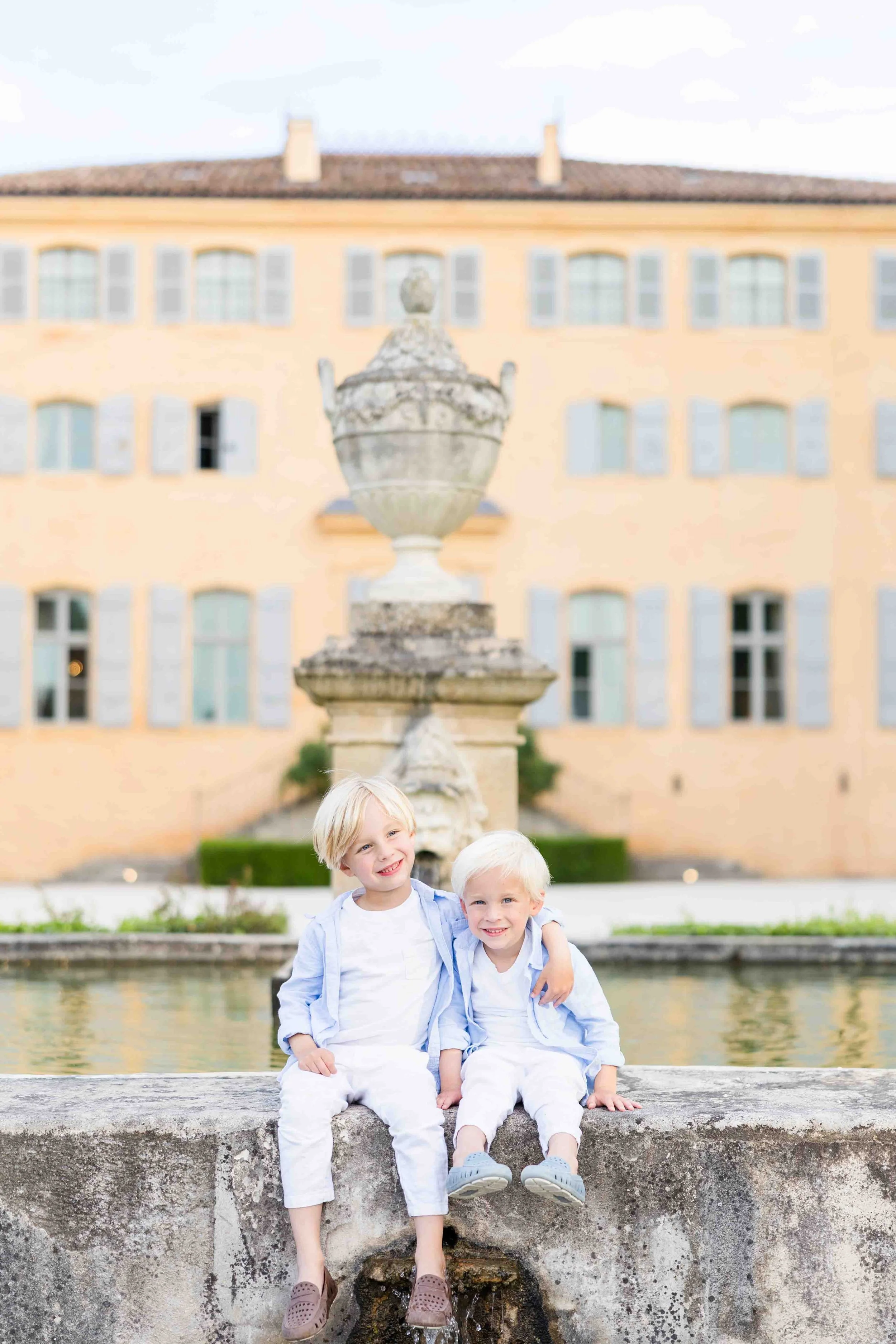 Children portrait in front of the historic fountain at Château de Fonscolombe, Provence.