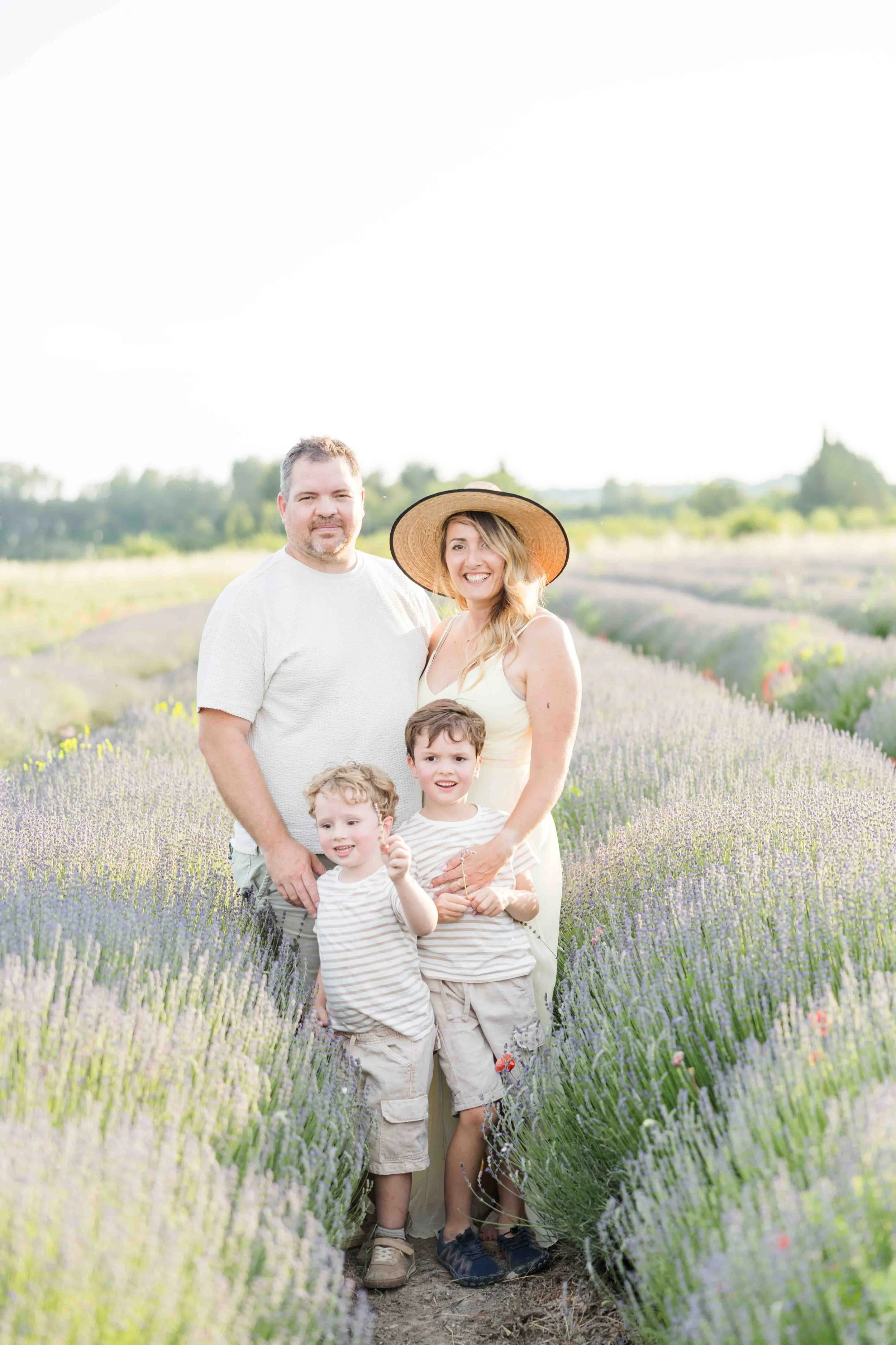Boys running in a lavender field in provence with their parents smiling and laughing everybidy happy
