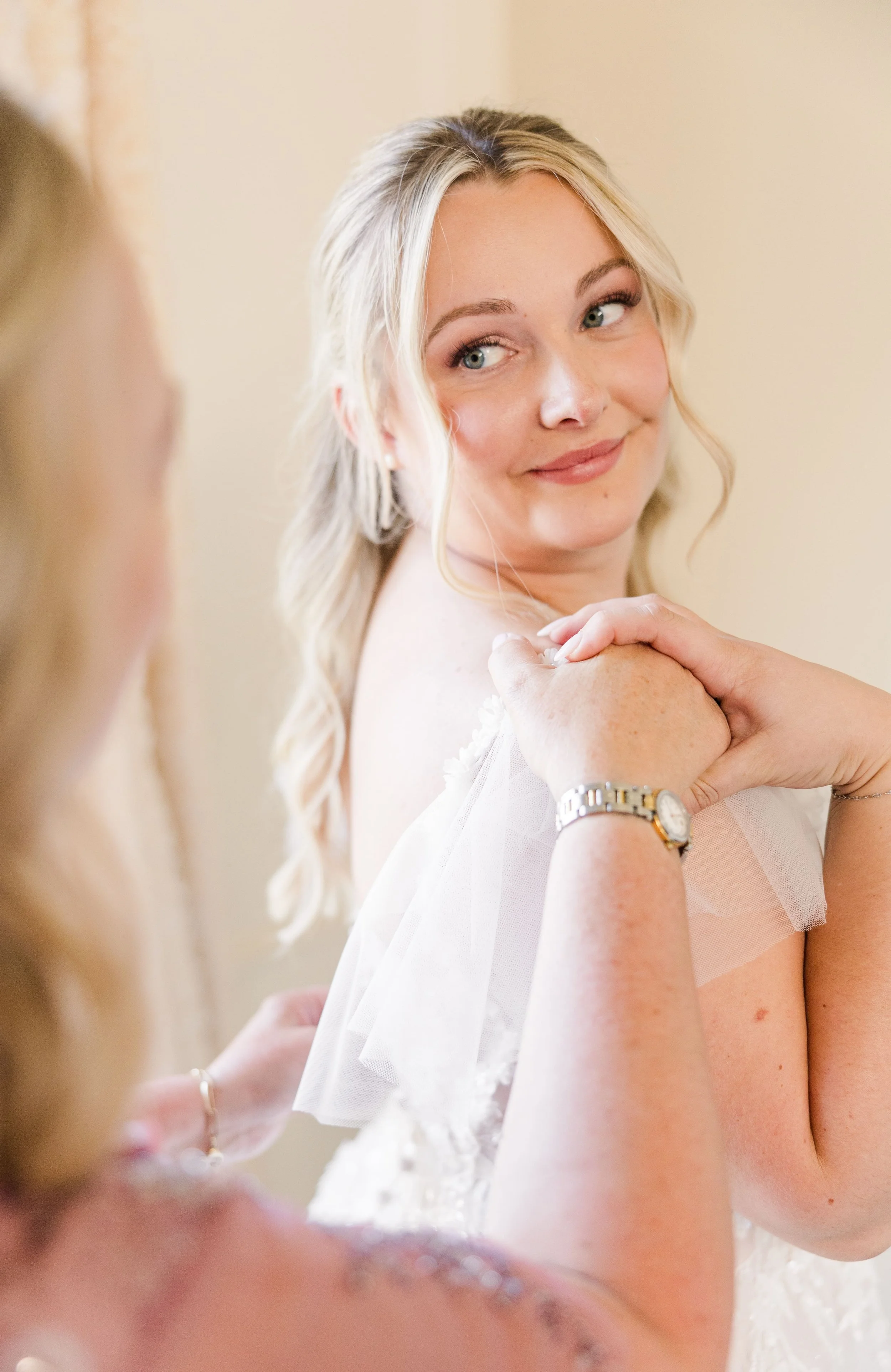 bride holding her mom's hand just after getting dress