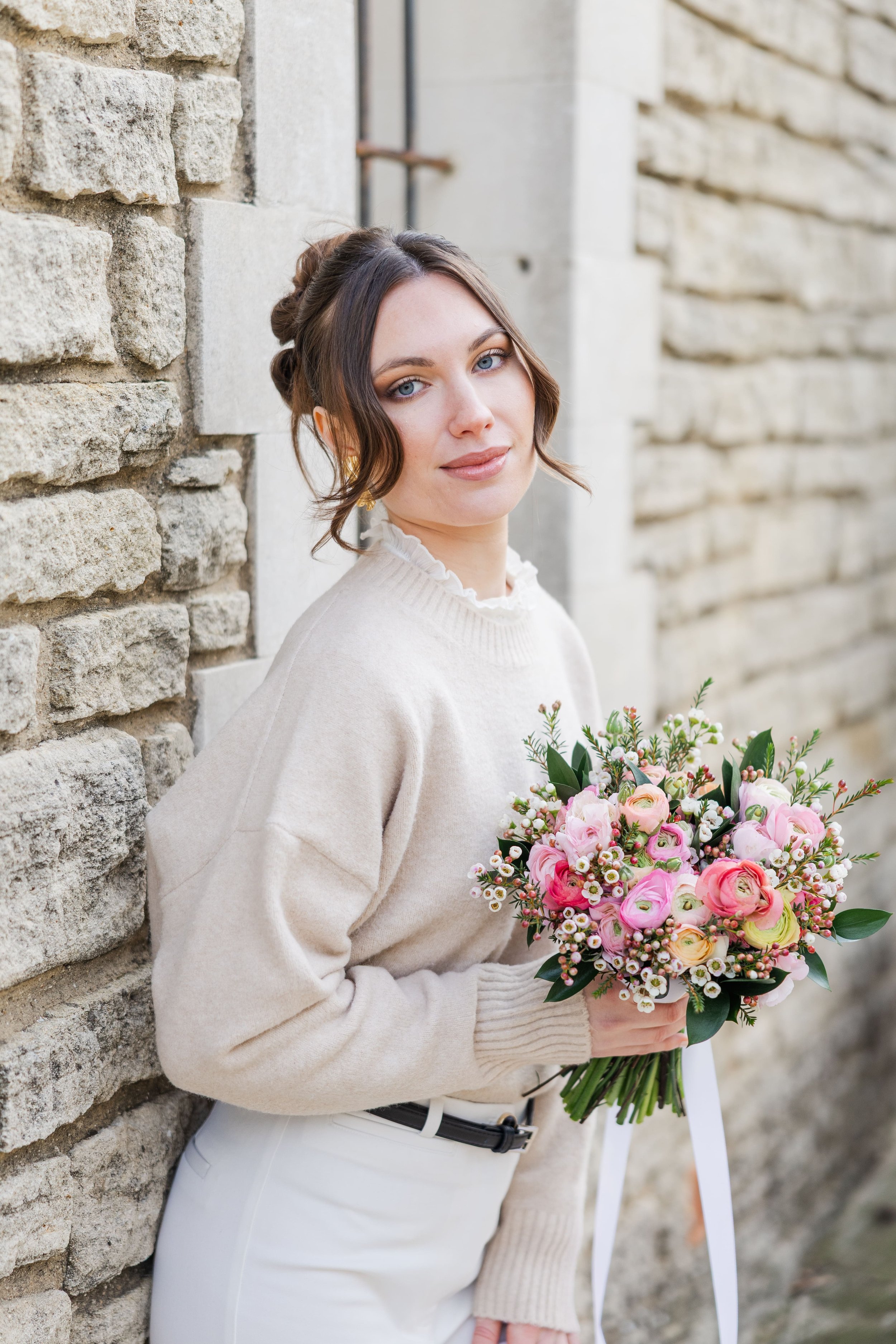 Woman posing gracefully among blooming pink flowers in Gordes, Provence