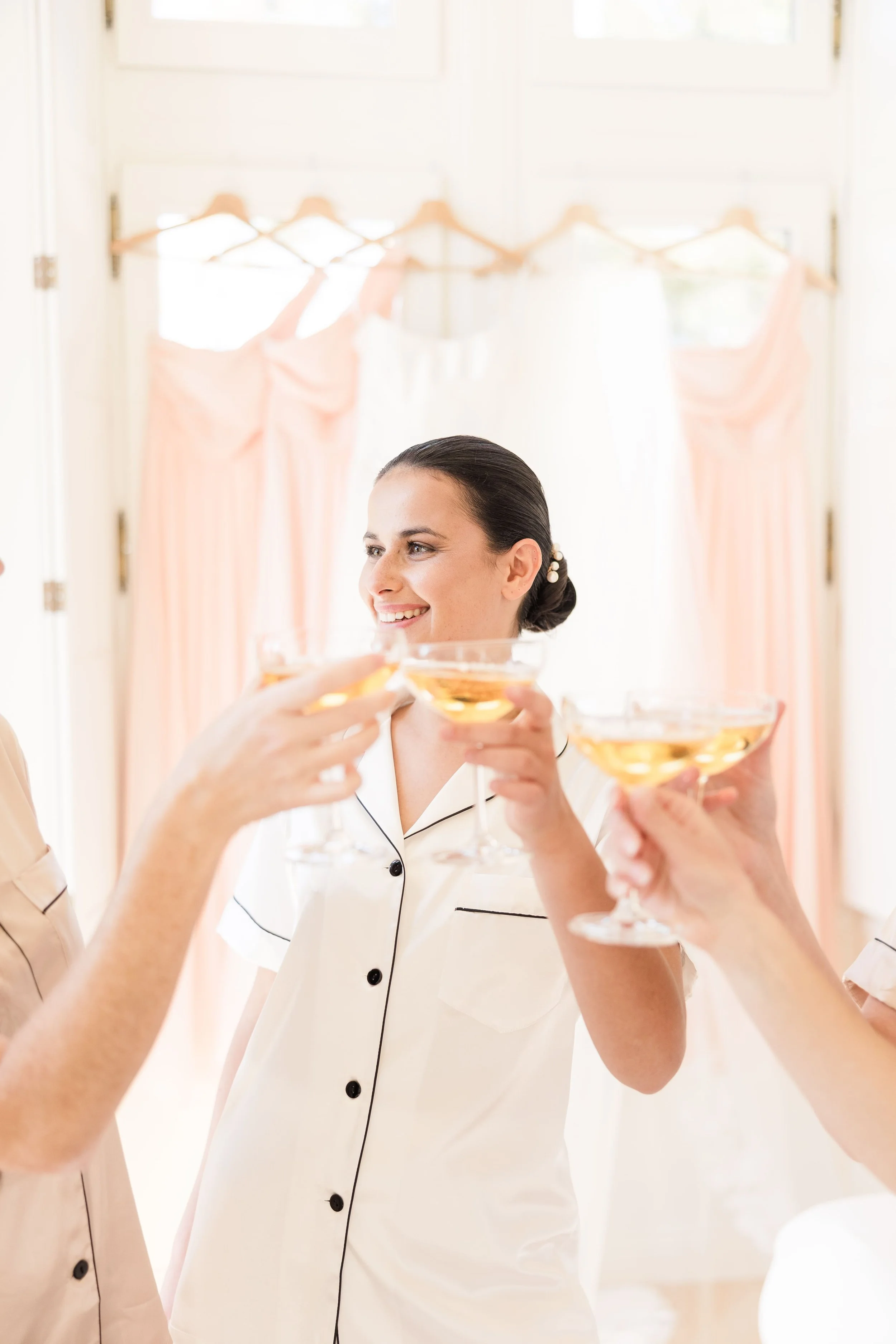Bride toasting with bridesmaids during a joyful wedding morning celebration