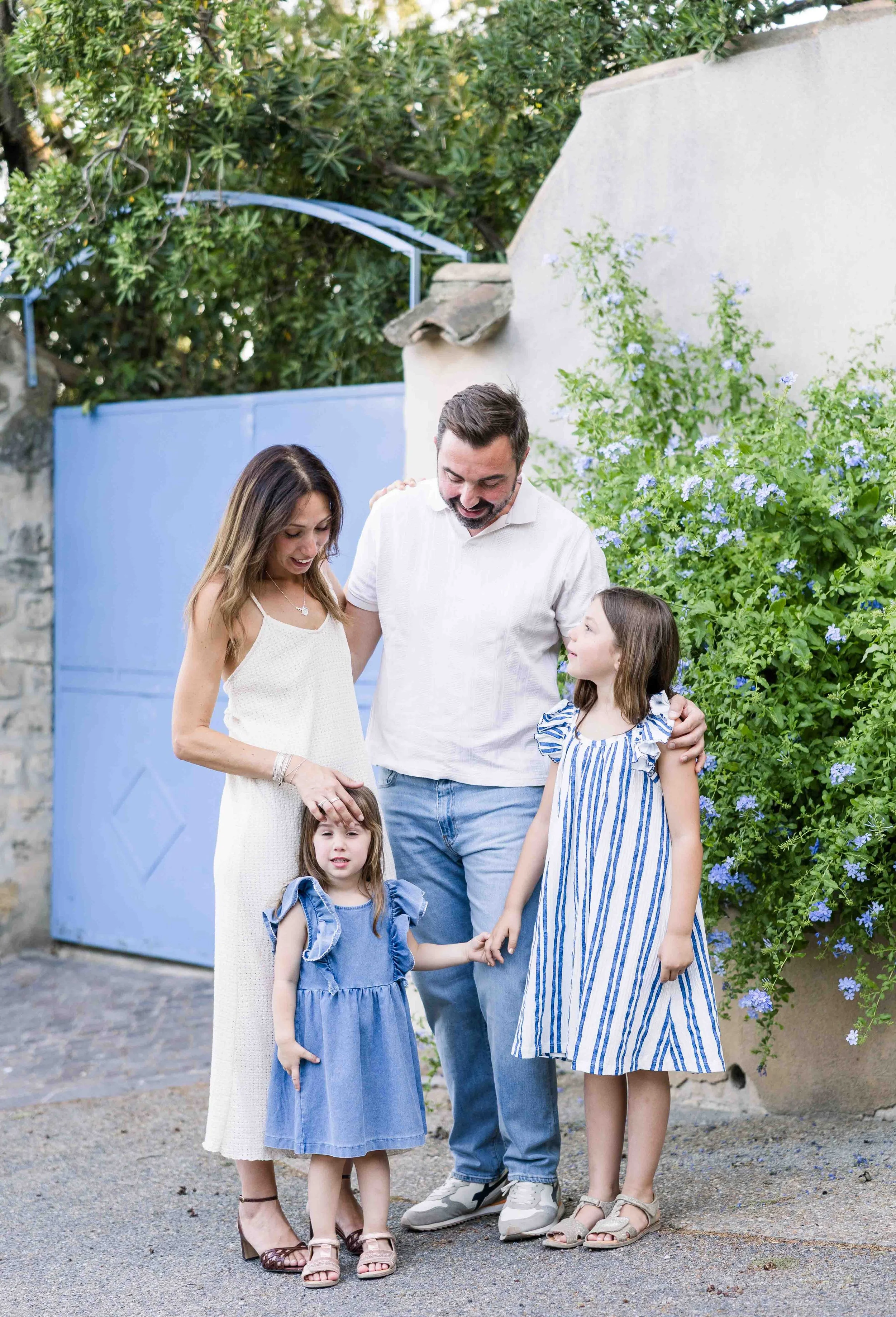 Family sharing a joyful moment beside a blue door in a beautiful Provençal village.
