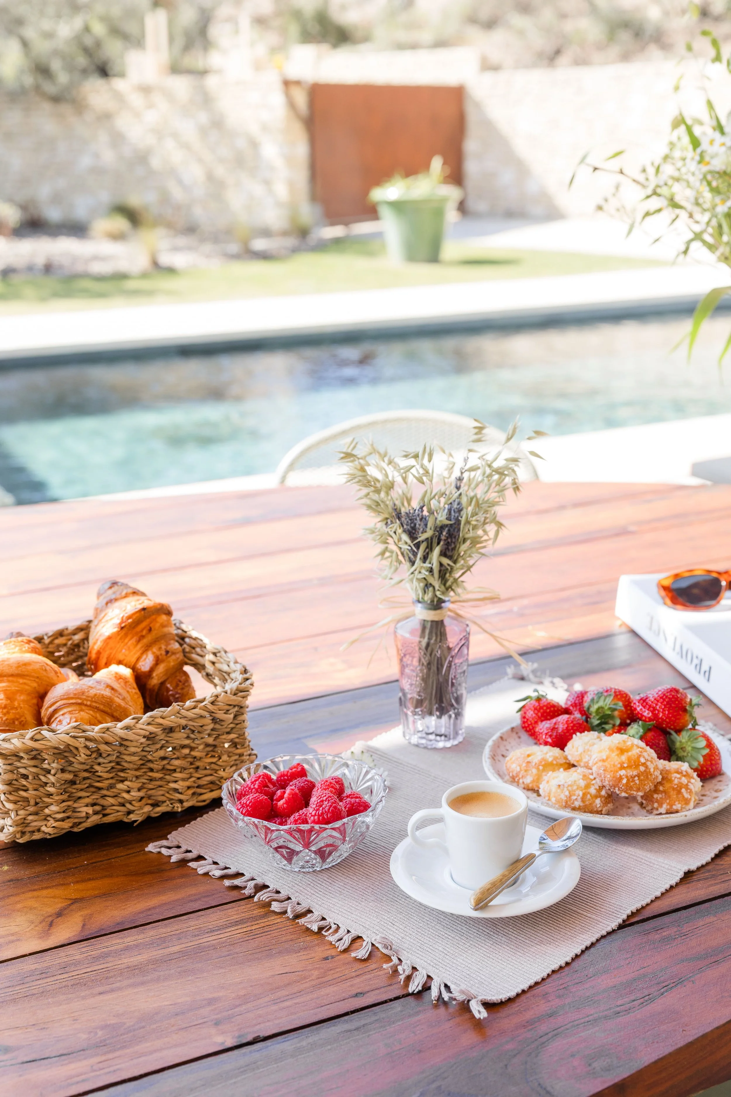 Outdoor breakfast setup with a woman in a luxury villa garden in Provence, soft morning light