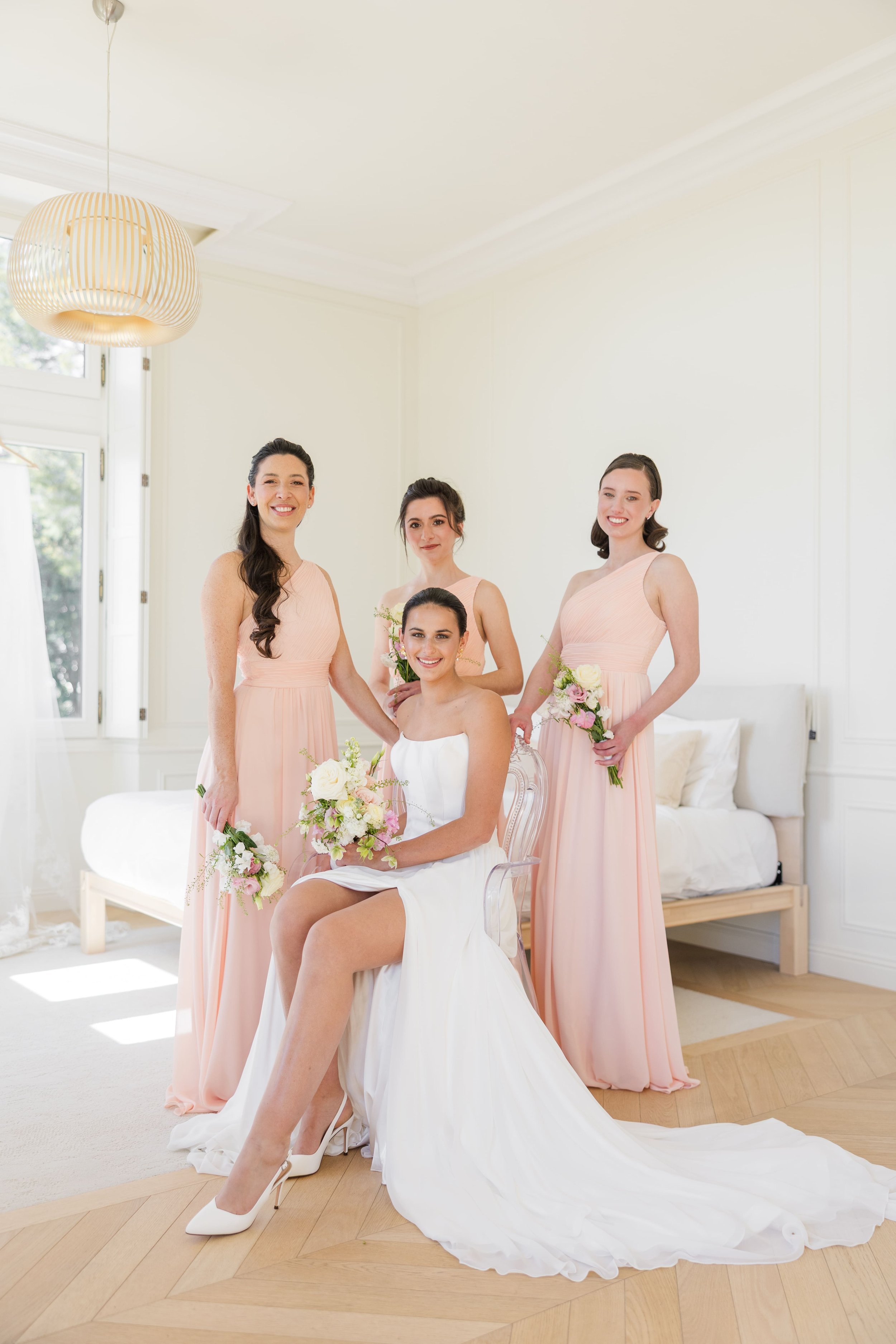 Bride and bridesmaids posing together in an elegant wedding portrait