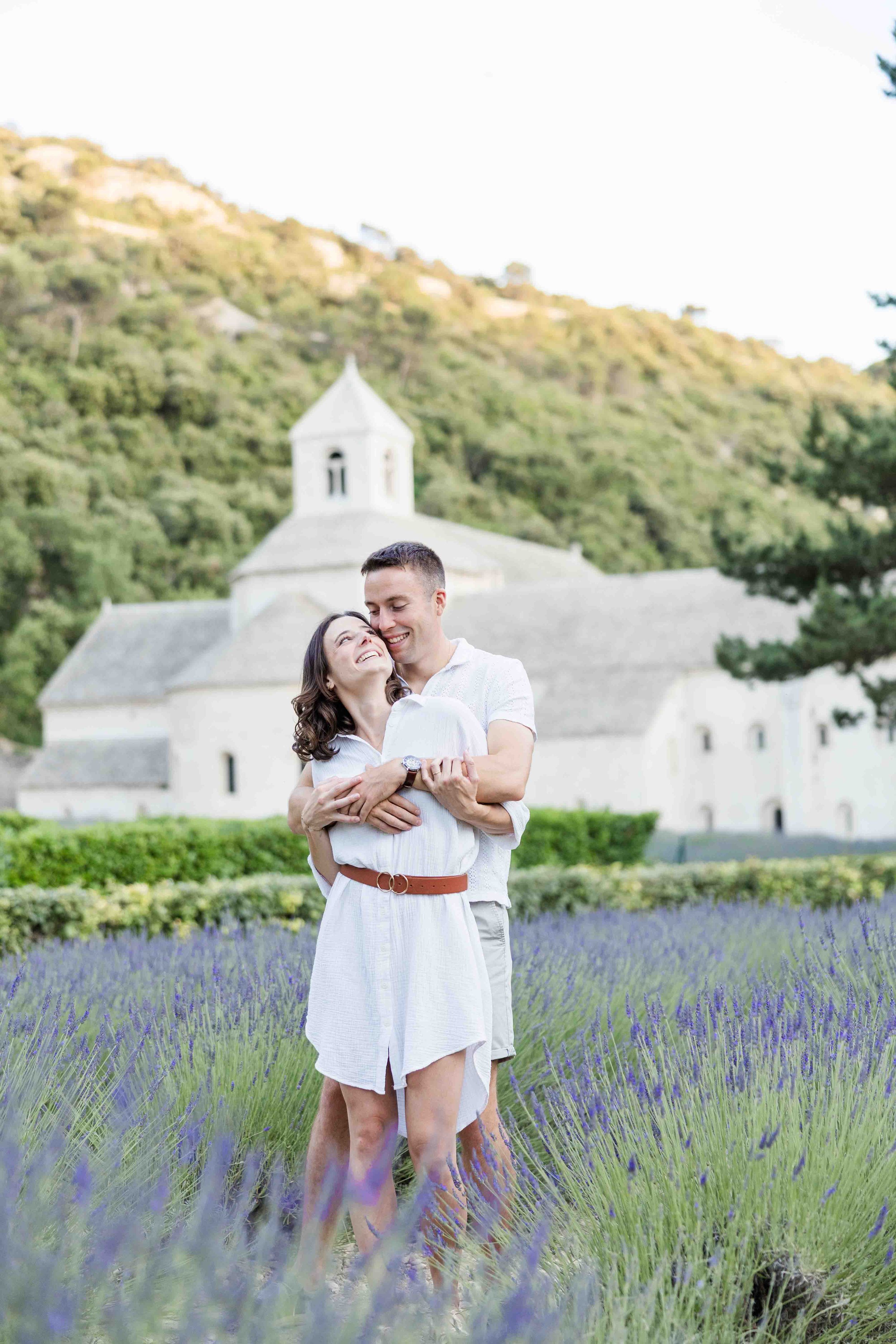 Couple portrait in front of Sénanque Abbaye after a surprise proposal in lavender field