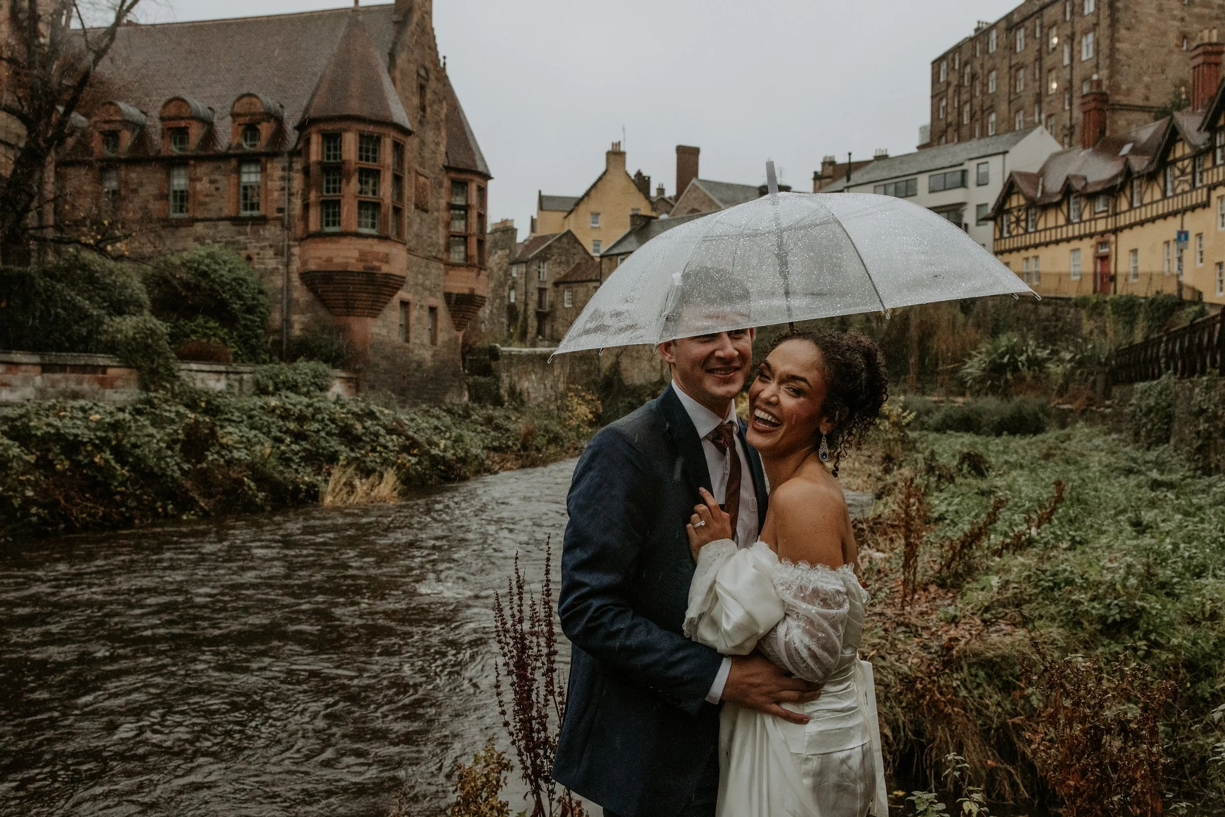 couple under clear umbrella during Dean Village Edinburgh Scotland elopement