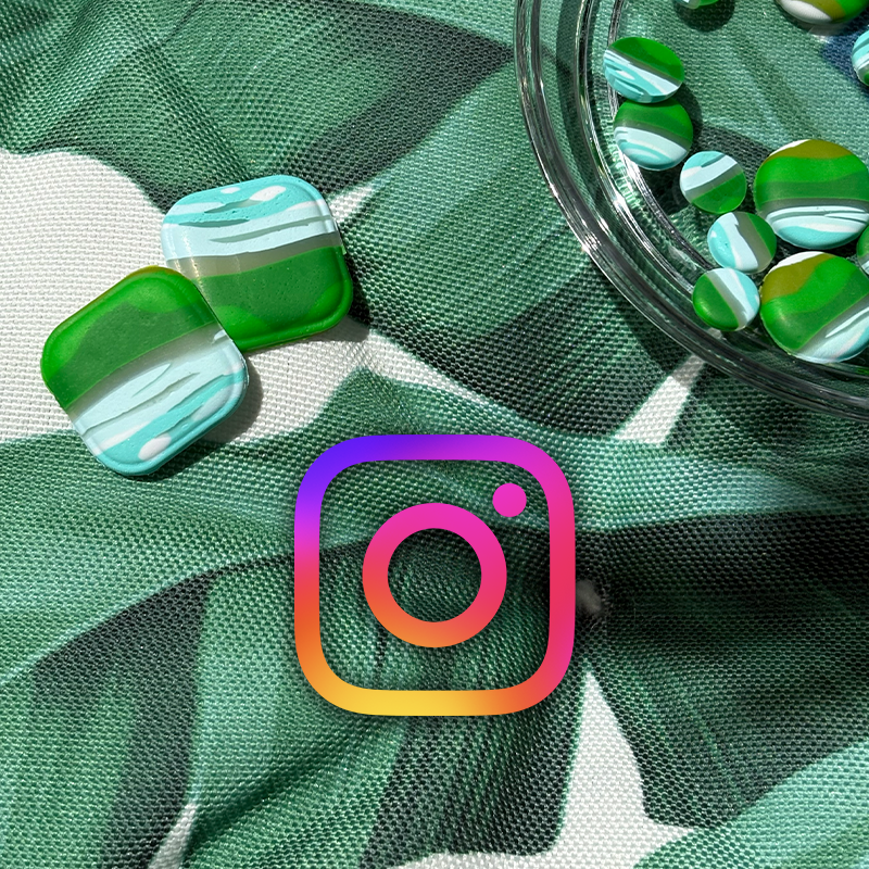 Green, white, and blue marbled candy on a green and white fabric surface, with more candies in a glass bowl nearby, and an Instagram logo overlay. The image is linked to the CradlingCreative Instagram channel.