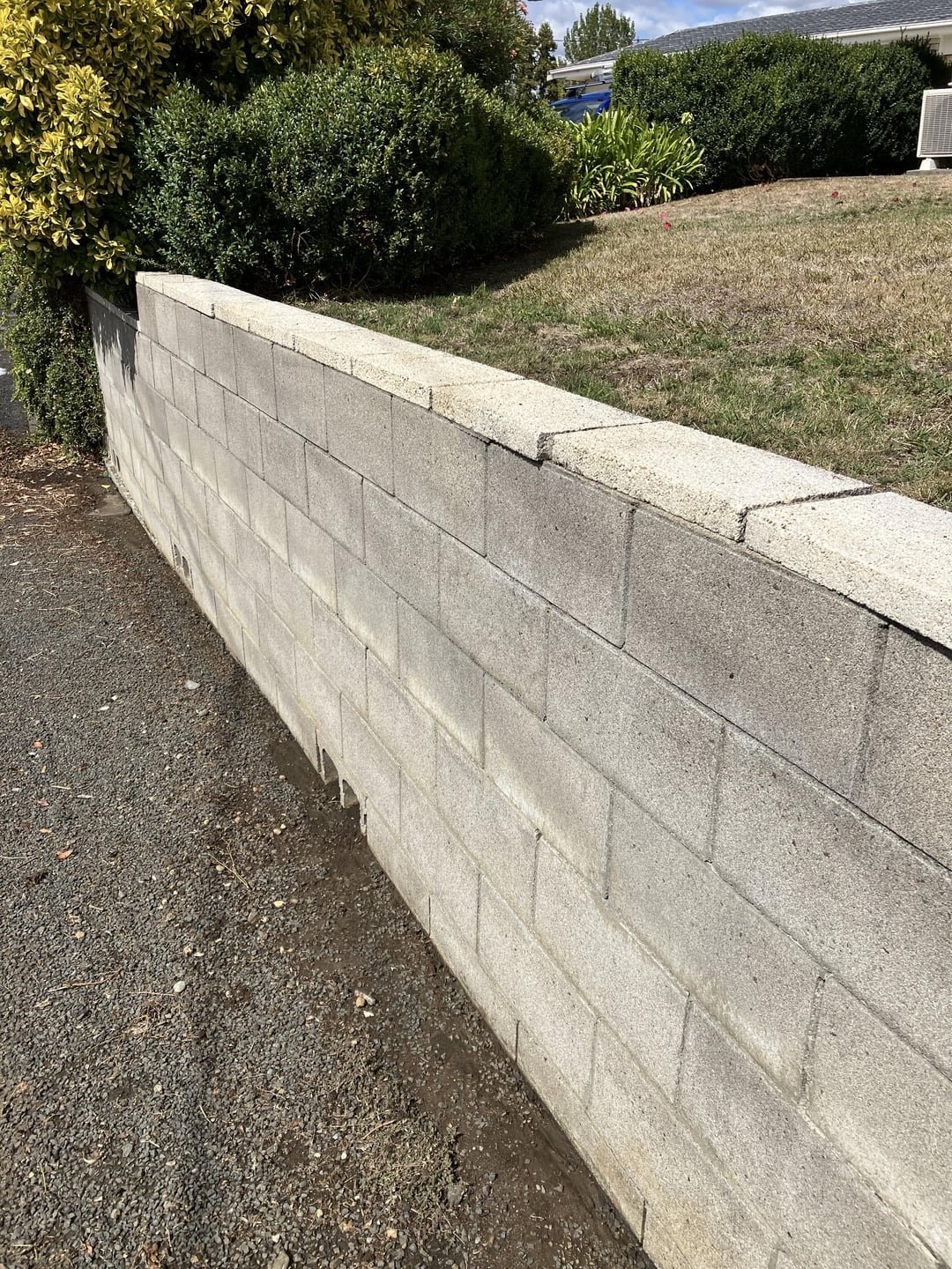 A concrete block retaining wall that has just been pressure washed. Concrete masonry pressure washing.