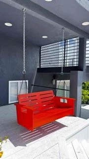 Securely installed red outdoor swing bench hanging from heavy-duty chains on a modern patio ceiling