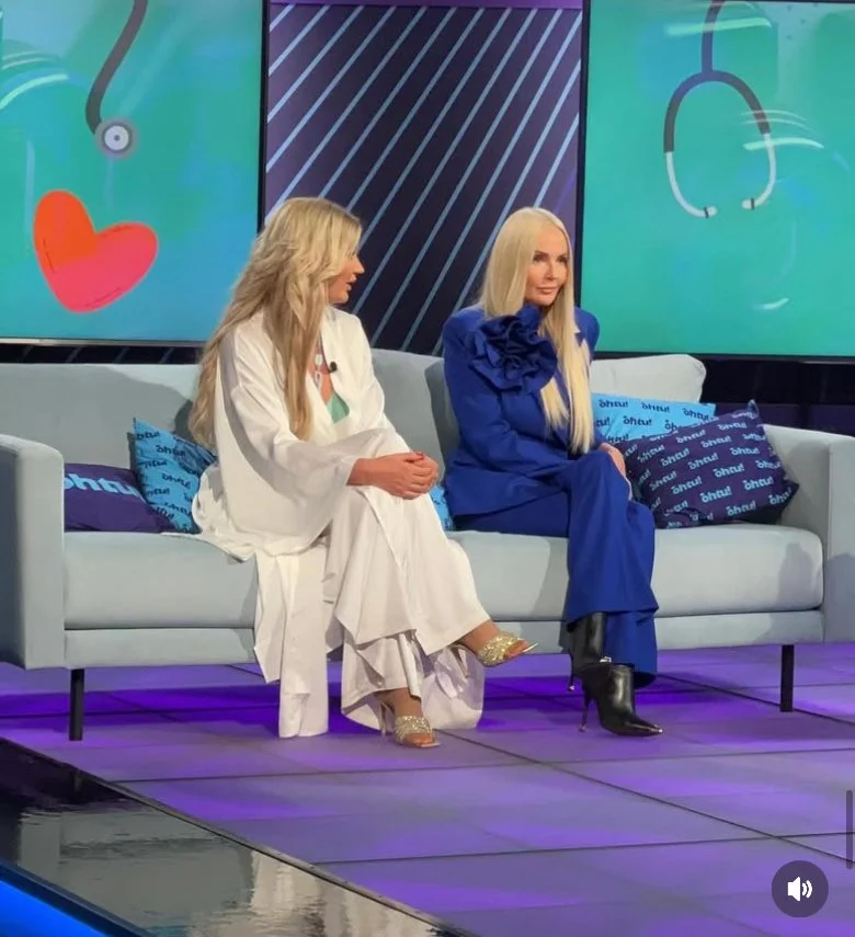 Kaksi naista istuu sohvalla televisio-ohjelmassa, taustalla on medisiin-aiheisia kuvia, kuten stetoskooppi ja sydän.