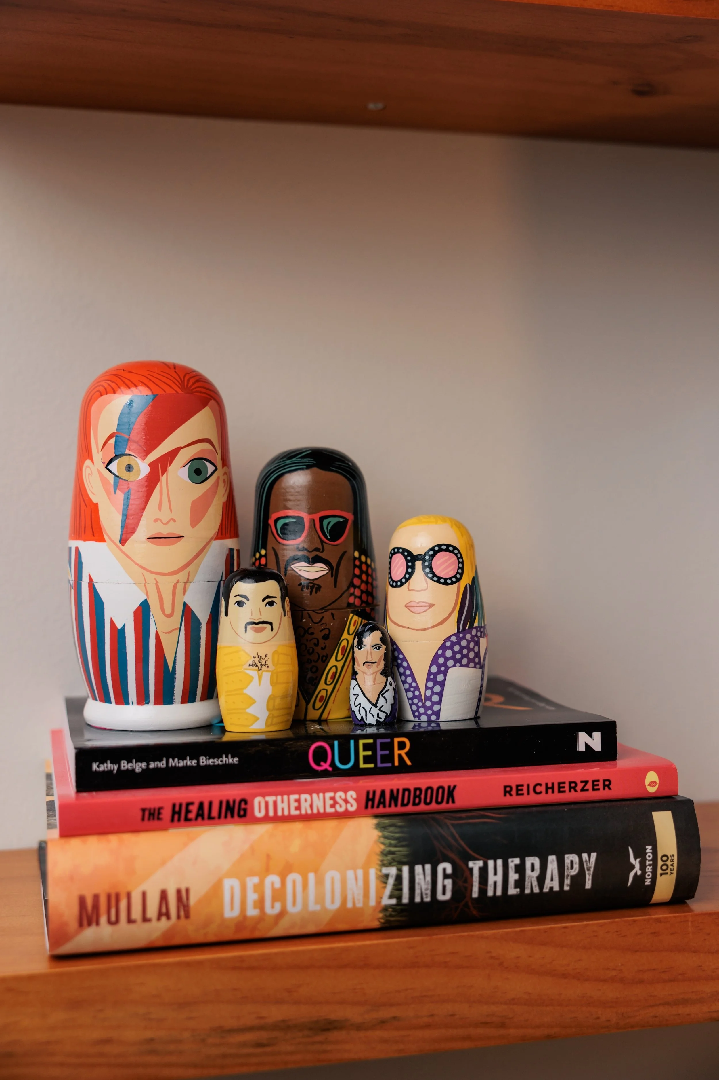 Celebrity Russian Dolls on a stack of books.