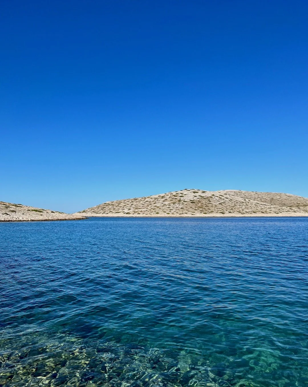 Clear blue sea and rocky shoreline of Kornati islands.