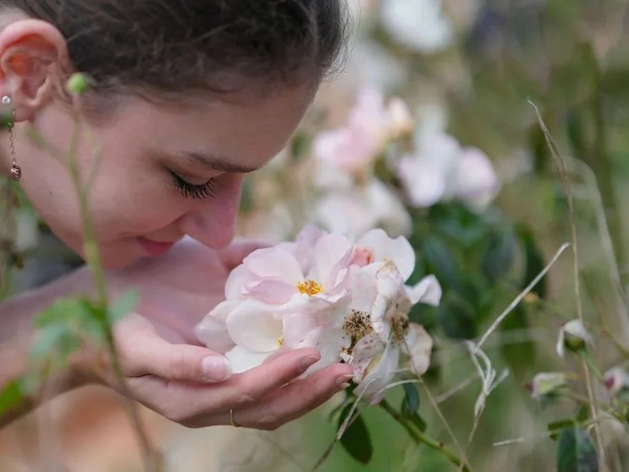 young lady smelling roses