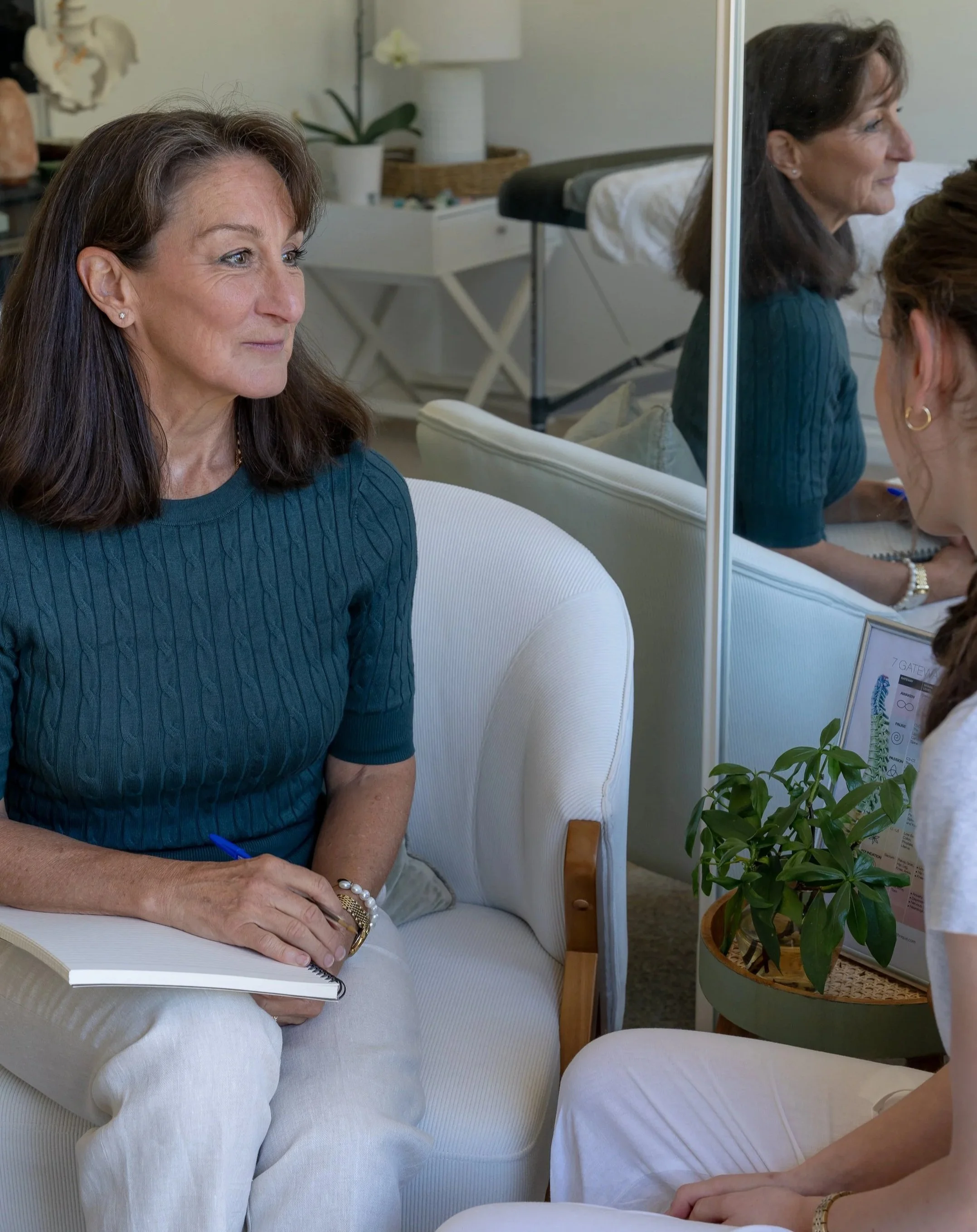 two ladies chatting outdoors at table with coffee