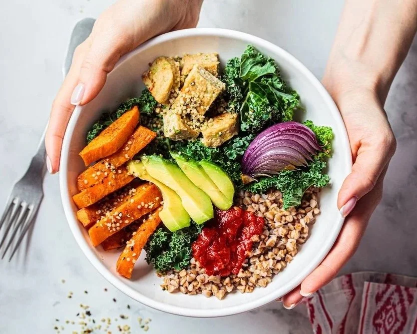 person holding bowl of healthy food. Kale, avocado, tofu, sweet potato