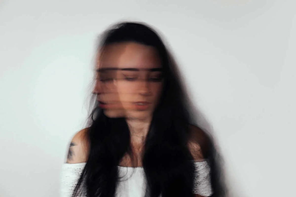 Frau mit langen Haaren, gesenktem Blick, schaut hin und her
