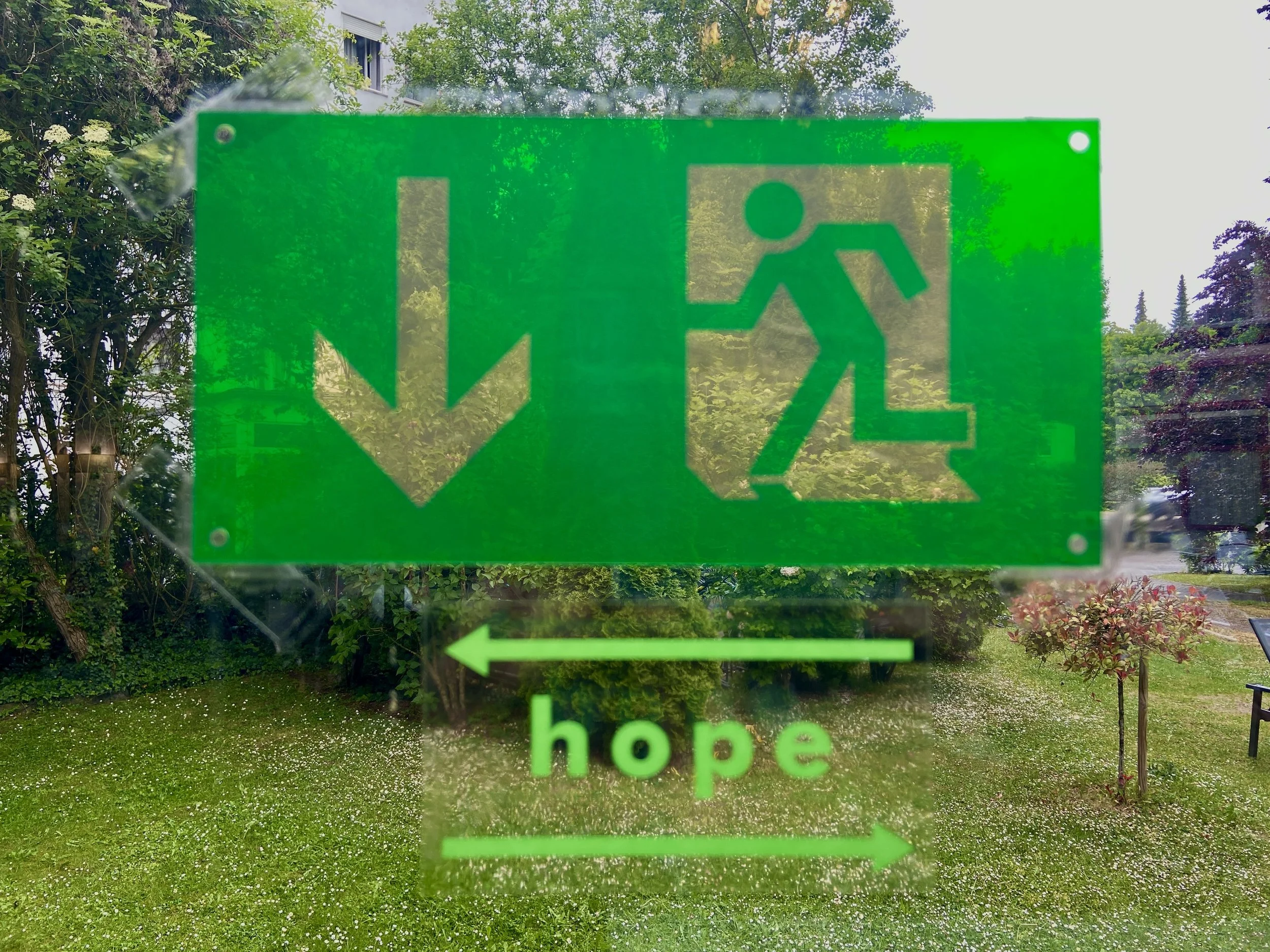 Notausgangsschild mit zusätzlichem Pfeil nach links mit dem Wort hope