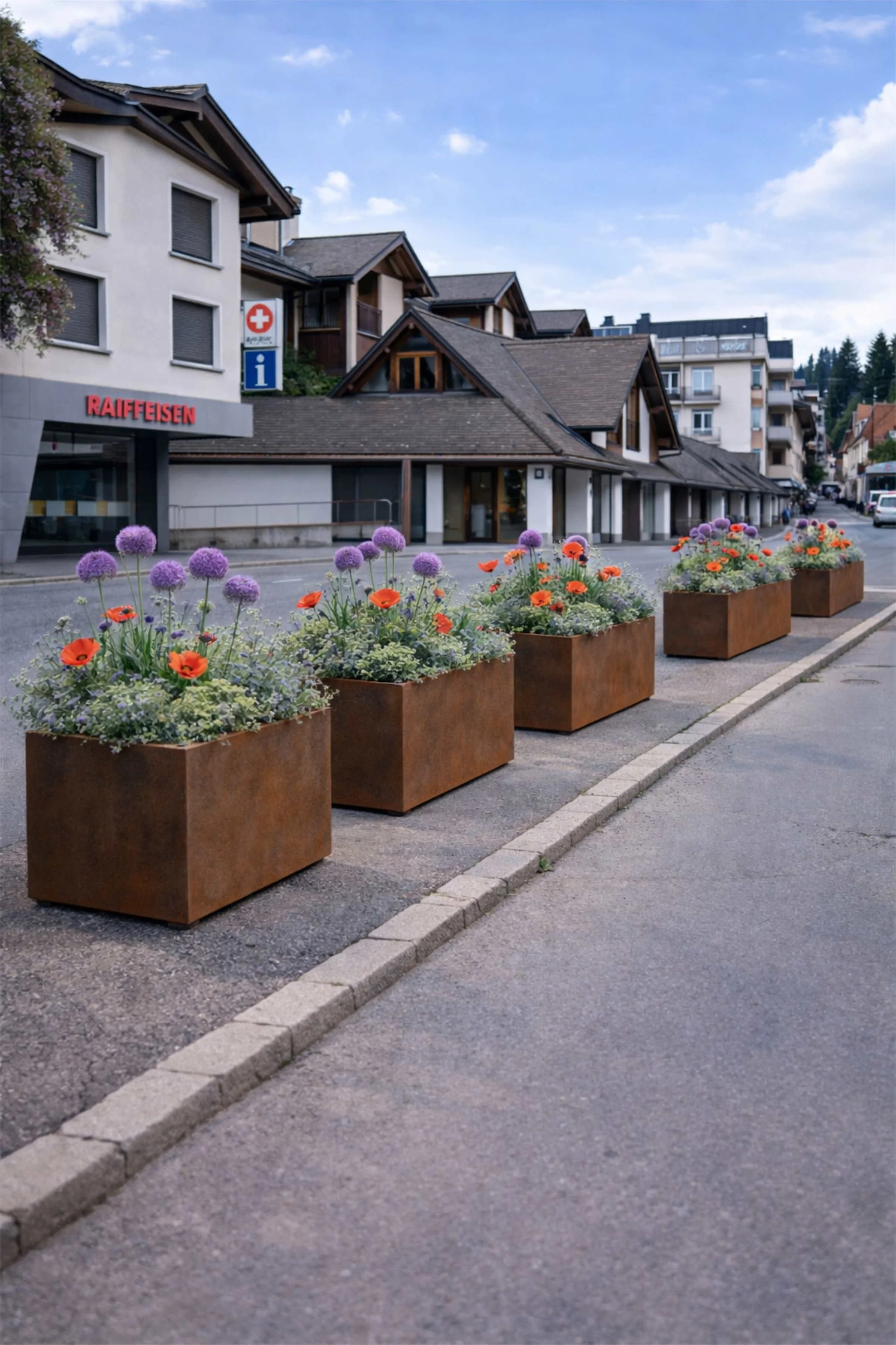 Begrünte Dorfstrasse mit Pflanztrögen und bunten Blumen