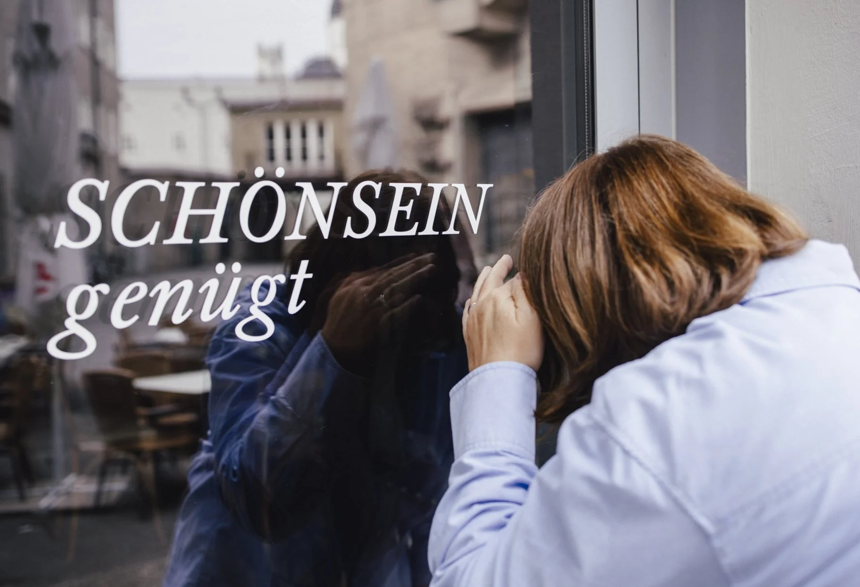 Frau schaut in ein Schaufenster