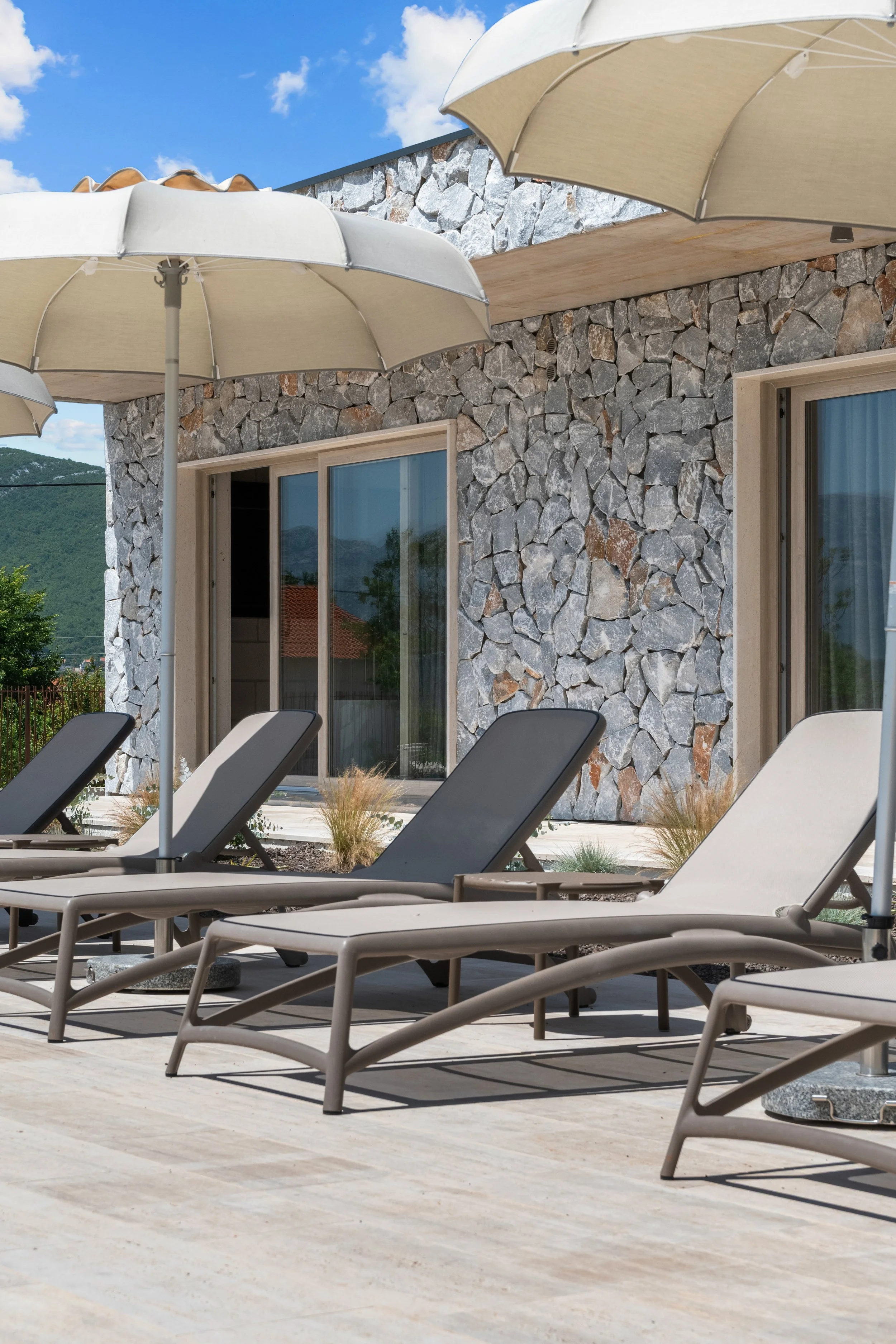 Ležaljke i suncobrani uz bazen – fotografiranje nekretnina