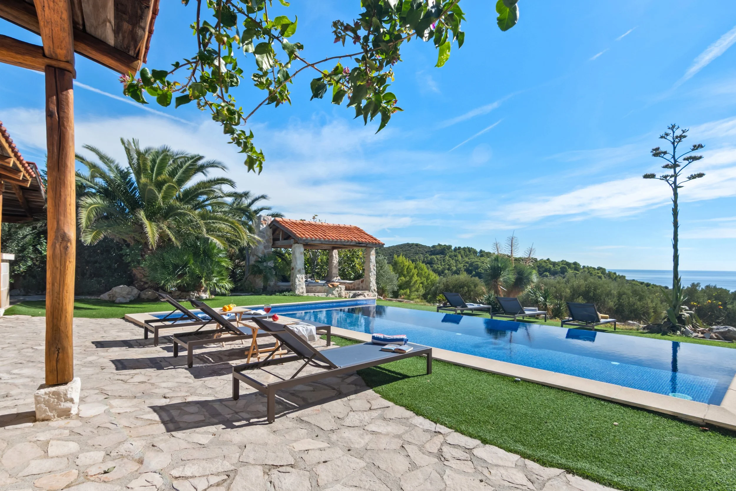 Ležaljke uz bazen s pogledom na more 