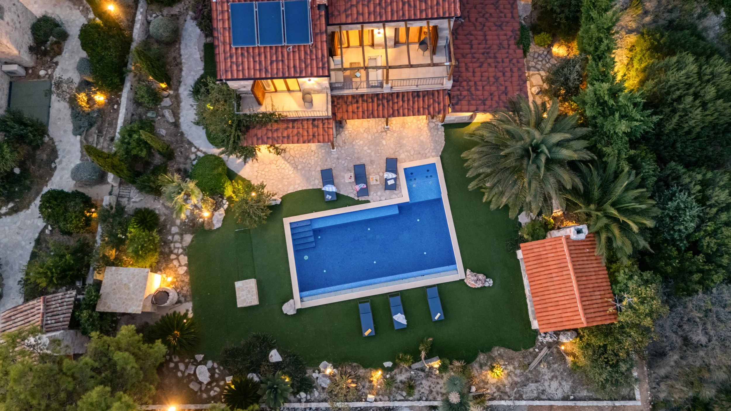 Snimak dronom na bazen i vilu noću 